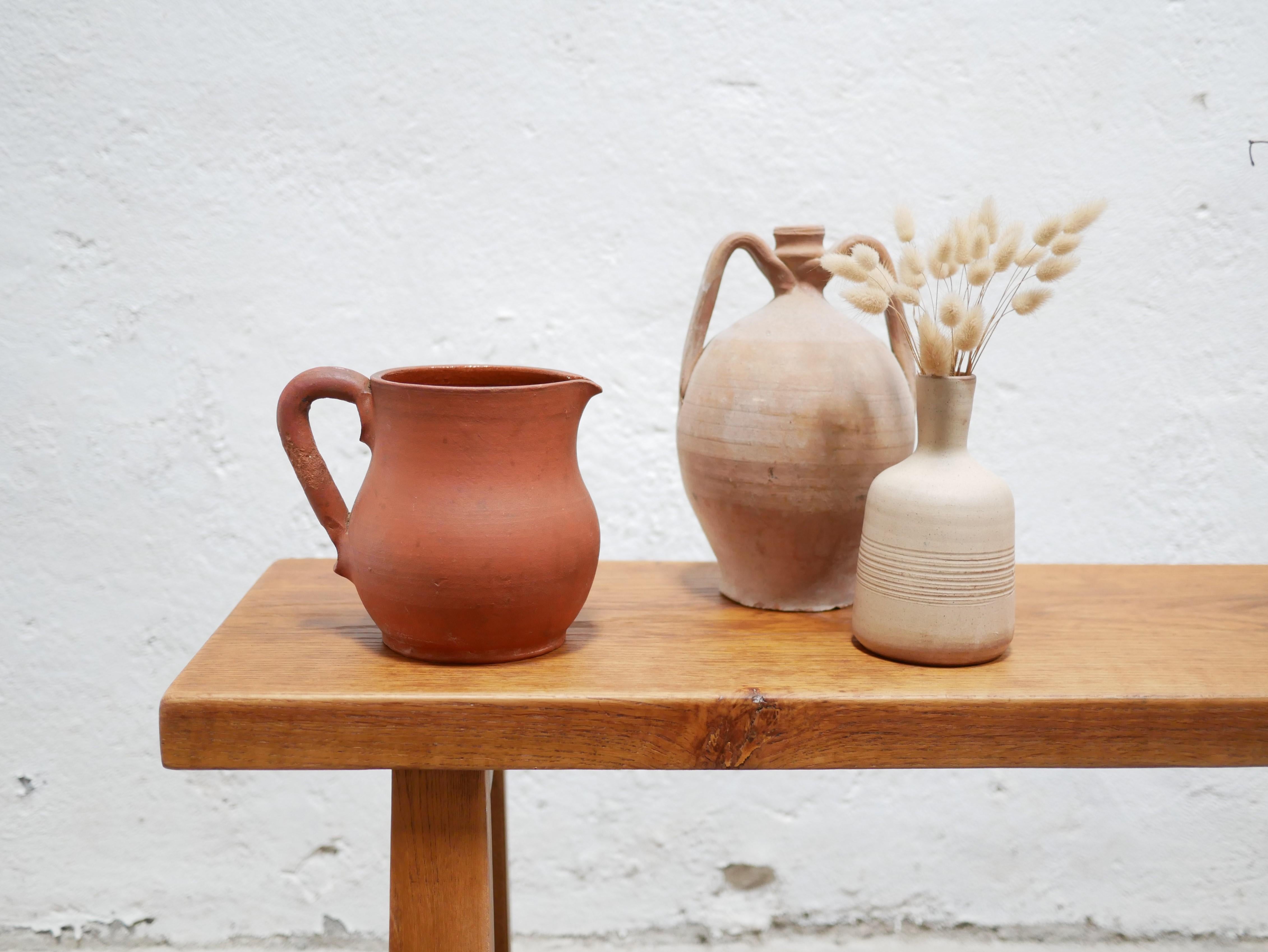 Terracotta pitcher from the 1960s.

With its modern shape and mineral hue, this ceramic will be perfect in a natural, refined and delicate decoration.
We simply imagine it placed on a shelf or piece of furniture, adorned with a few dried flowers