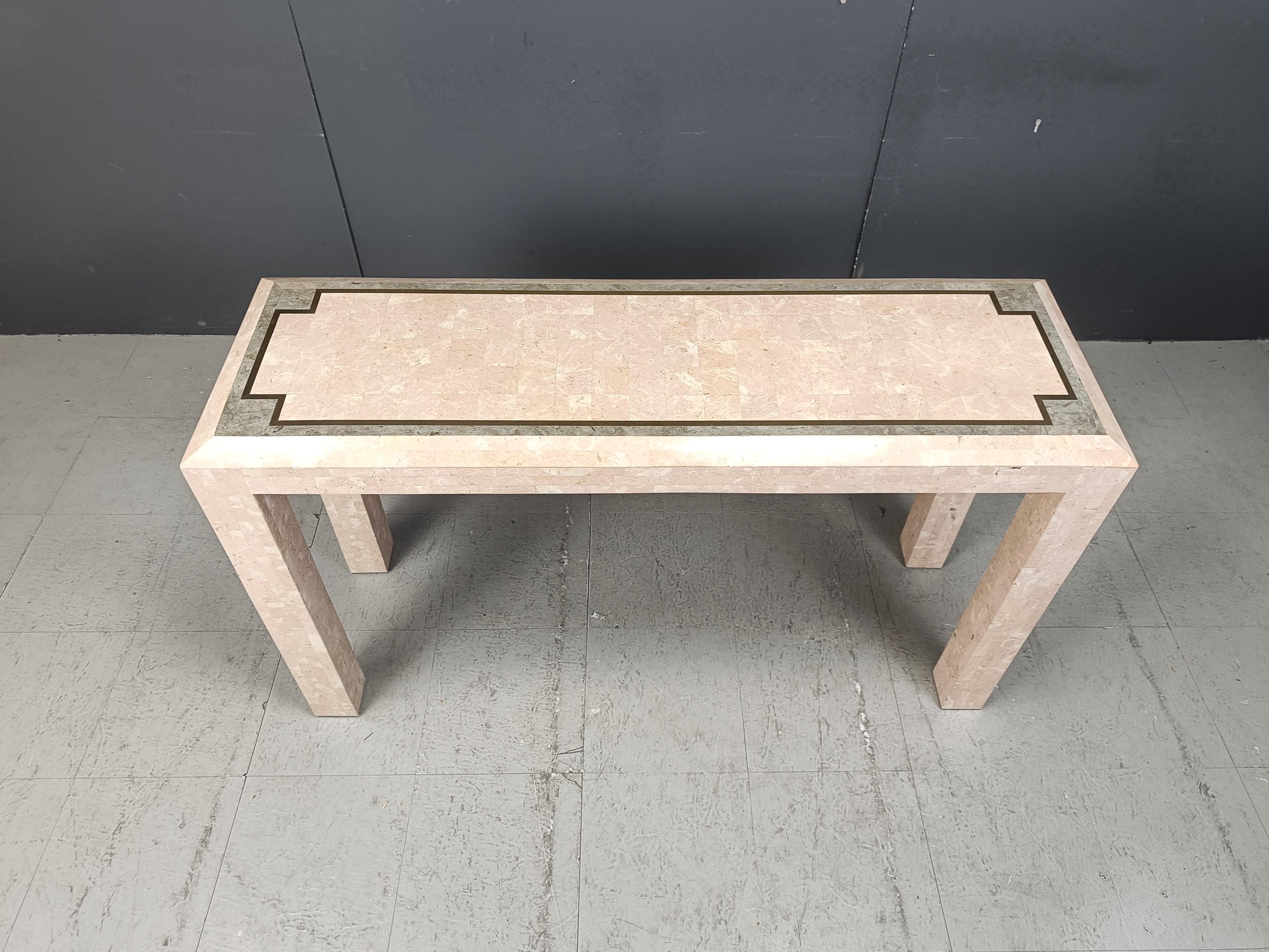 Elegant vintage hallway table or console in the manner of Maitland Smith.

Beautiful inlaid mozaic sheets of Pink/beige/grey stone on a wooden frame with inlaid brass lining.

Very good condition

Dimensions
Height: 75cm
Width: 130cm
Depth: