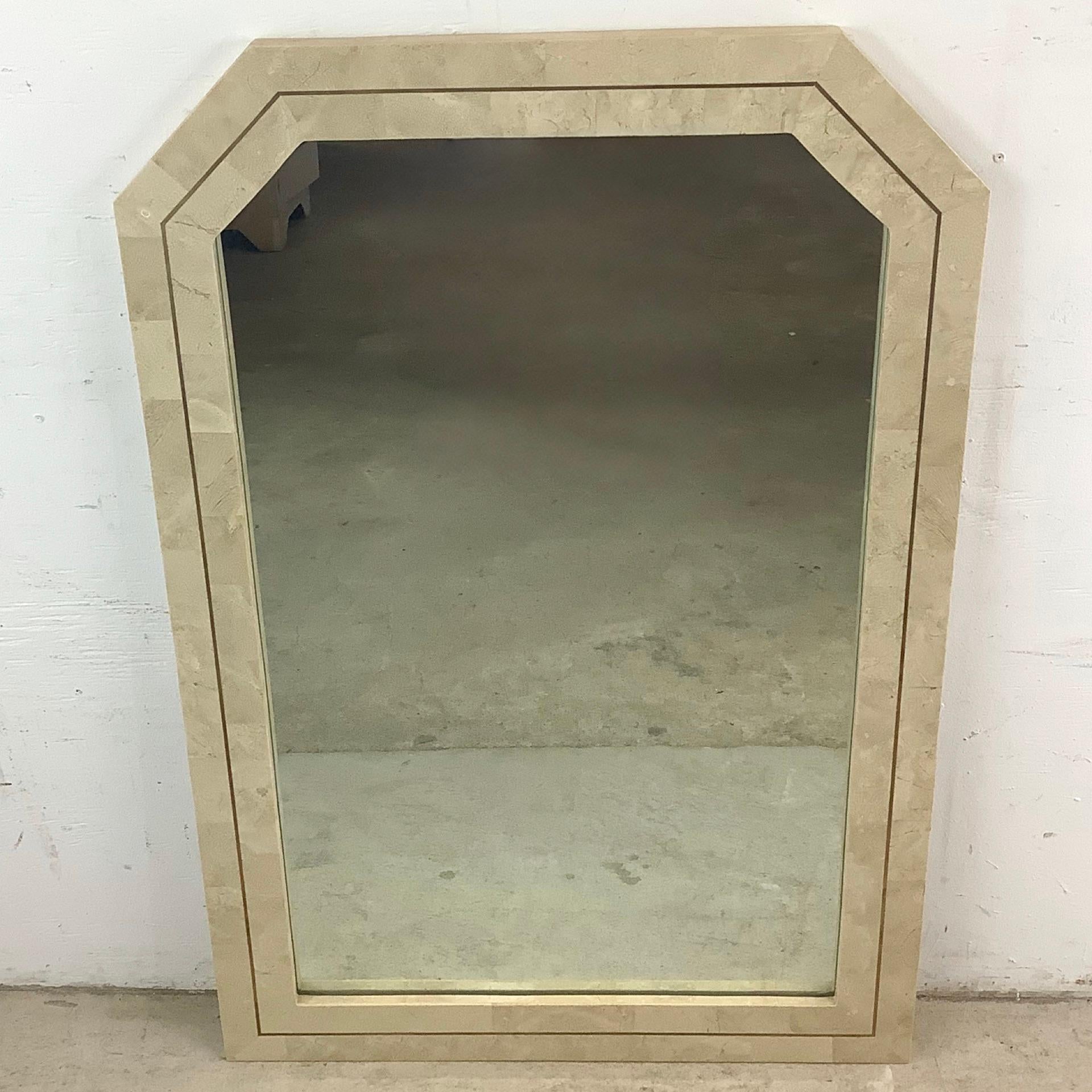Fusion étonnante de pierre naturelle et de laiton poli, ce miroir mural vintage de style Maitland-Smith témoigne d'un design intemporel et d'un savoir-faire artisanal de luxe. Avec son cadre en pierre tessellée et sa garniture en laiton incrusté, ce