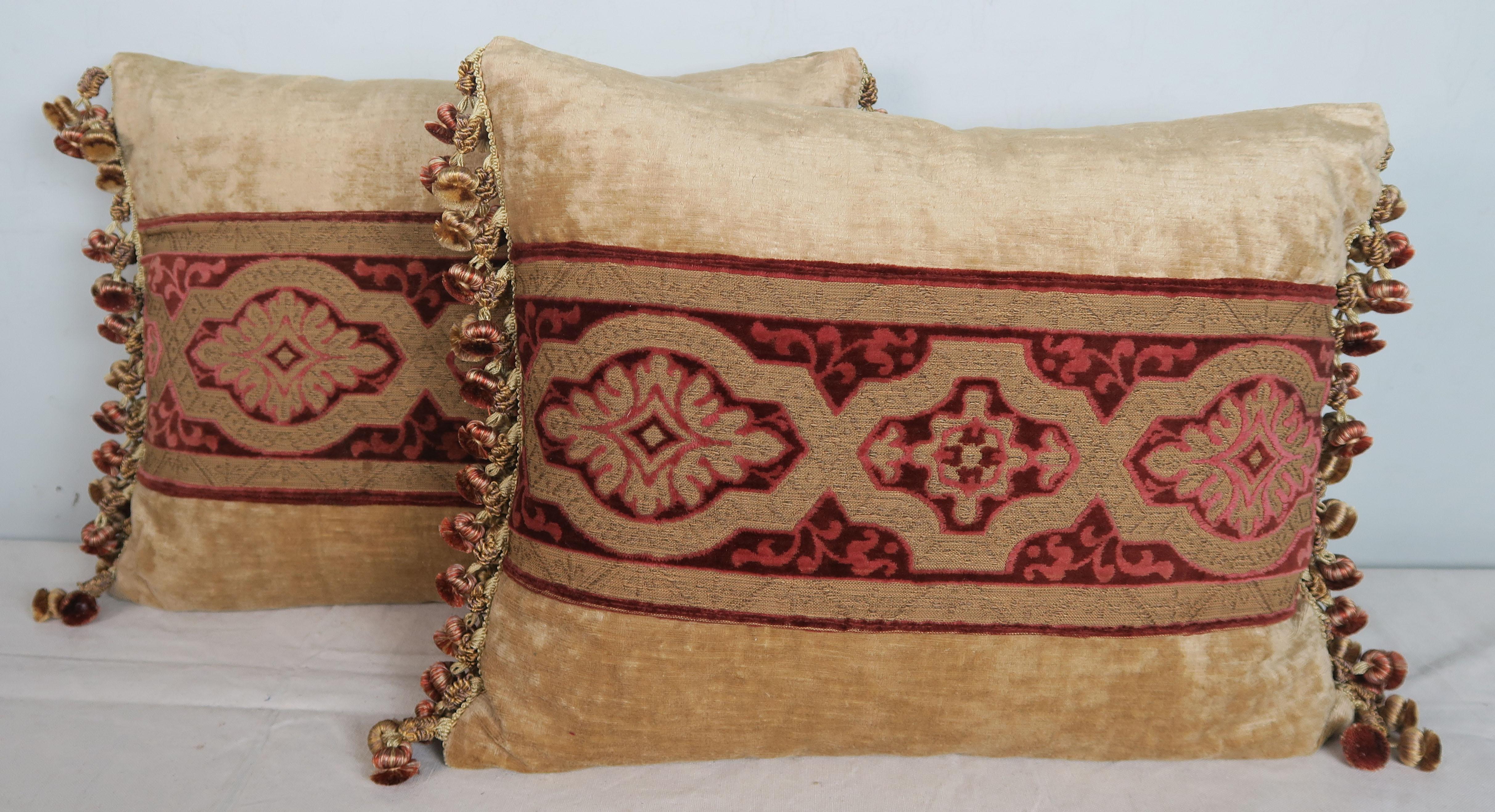 Pair of custom pillows made with vintage cut raspberry colored velvet combined with a flat antique gold metallic design. The vintage textile runner is flanked with soft cream colored linen velvet fronts and golden silk backs. The tassel trim down
