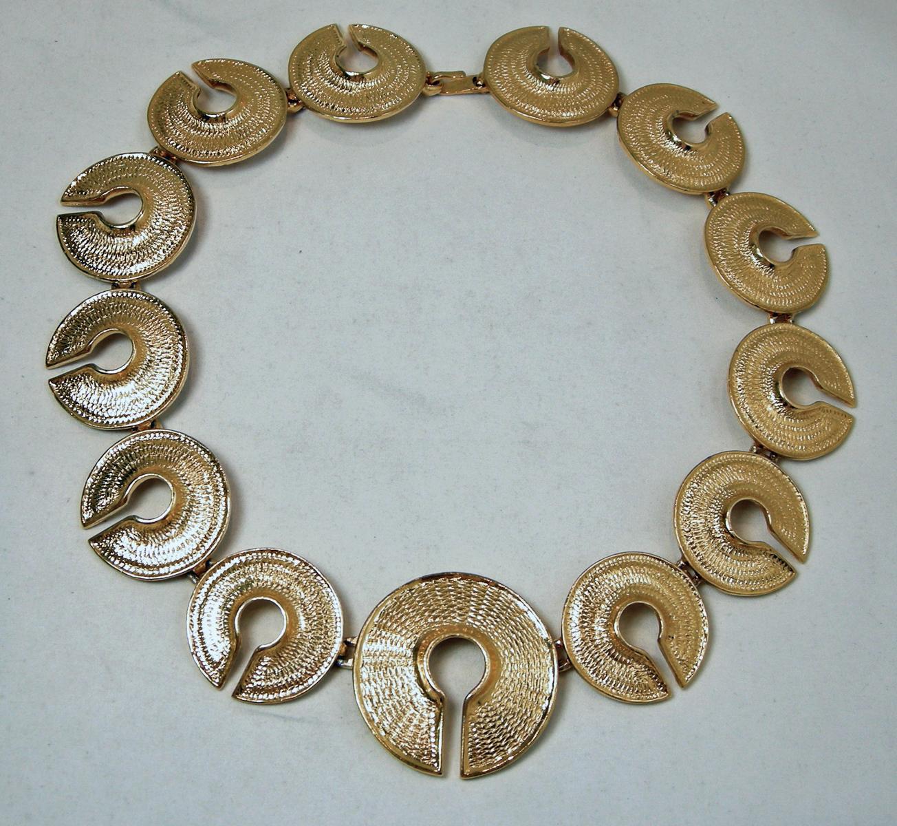 This vintage necklace has textured gold tone circle links going completely around to a hook clasp.  This necklace measures 18” long with the center circle measuring 1-1/2”. The others circular links are 1-1/4”.  This necklace is in excellent