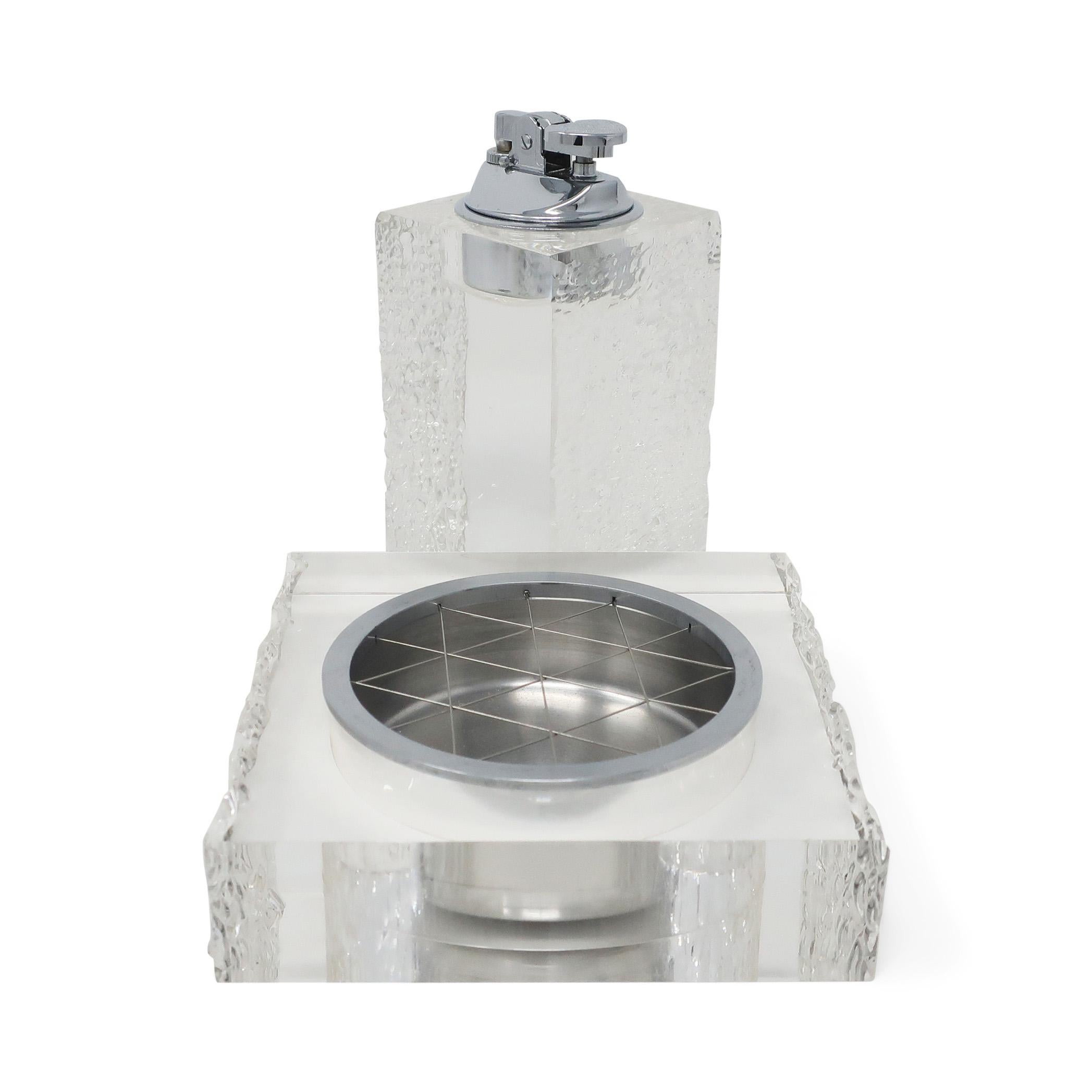 A Mid-Century Modern lucite lighter and ashtray set in the style of Felice Antonio Botta. The tall table lighter has two textured and two polished sides with a polished chrome lighter insert with new flint. The ashtray has matching textured and