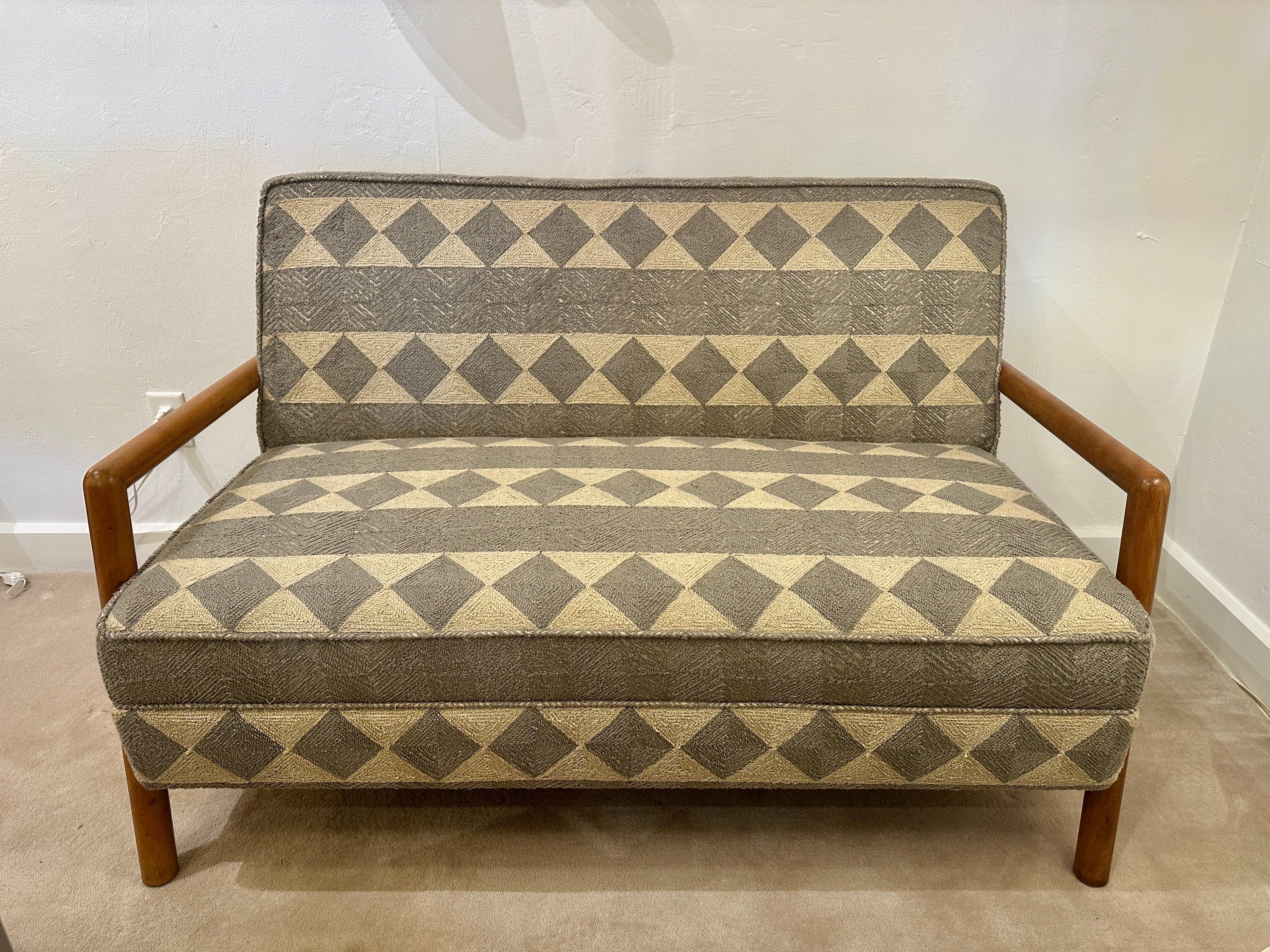 Loveseat by T.H Robsjohn Gibbings, for Widdicomb. This sofa features rounded original solid bleached walnut wood frame with armrests. The cushions have been newly reupholstered in a gray and cream thick woven tribal style fabric.

Dimensions: 53.5