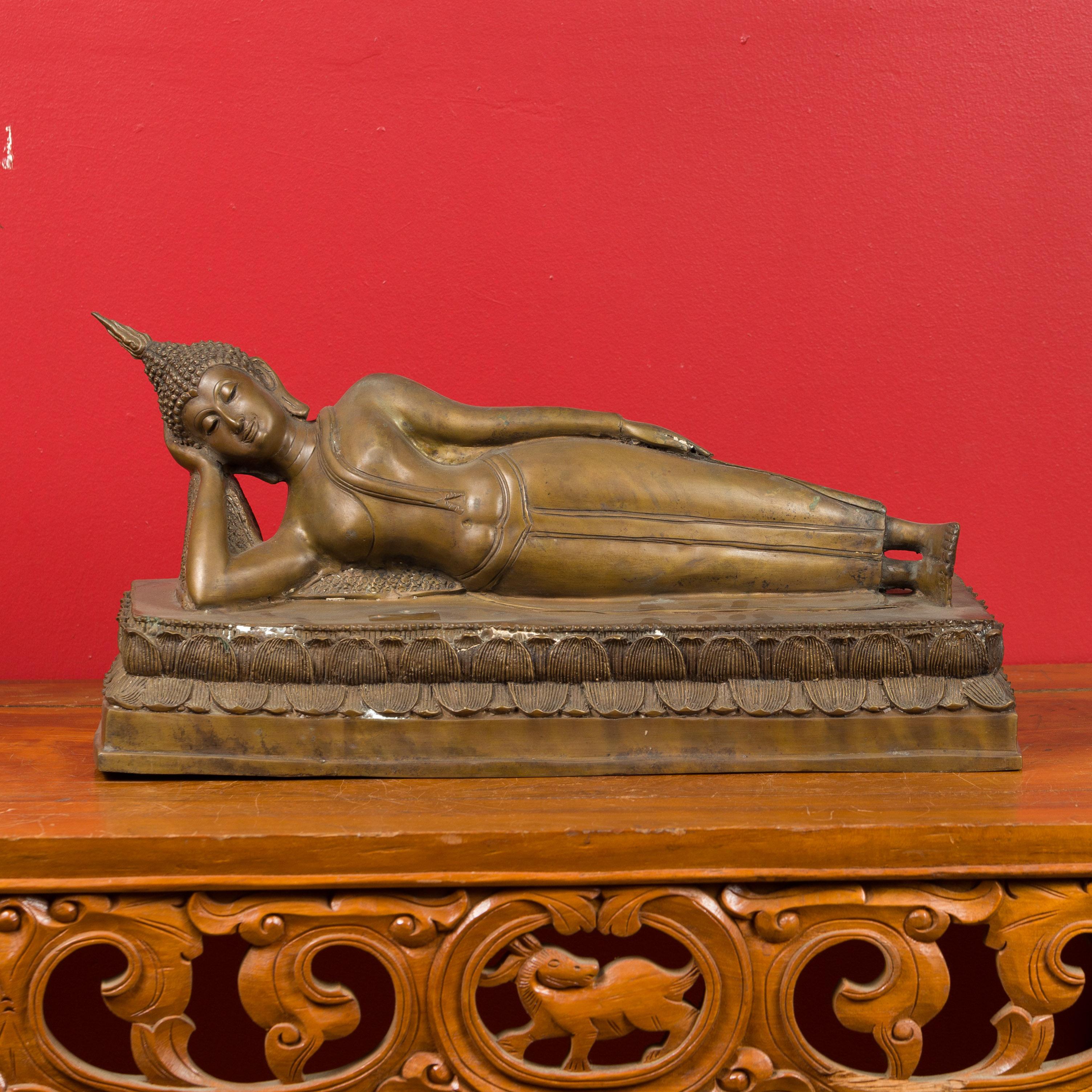 Bouddha couché sur socle en bronze thaïlandais à la cire perdue, inspiré du Bouddha du temple Wat Pho à Bangkok. Créée selon la technique traditionnelle de la cire perdue qui permet une grande précision dans les détails, cette sculpture vintage