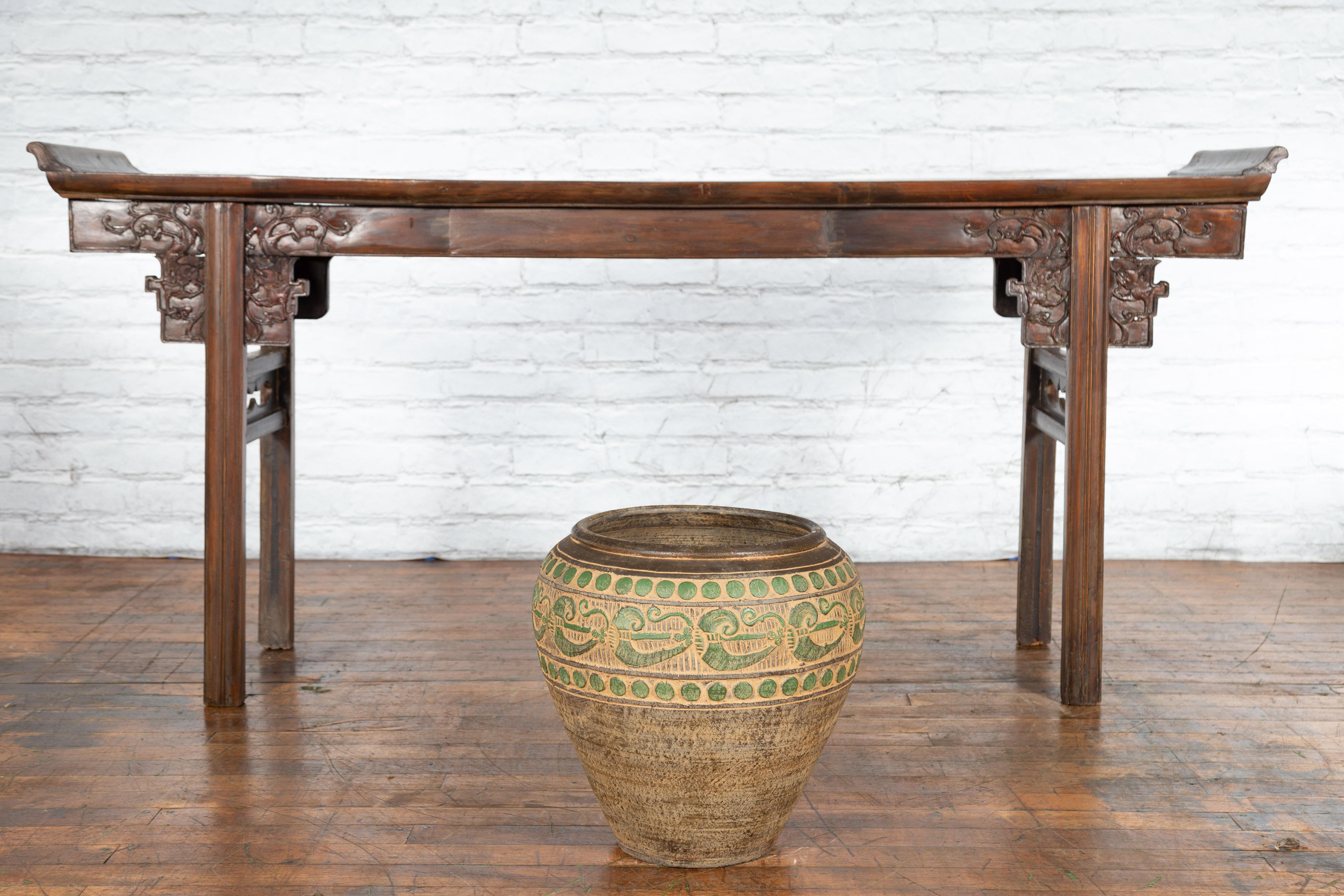 A vintage Thai brown jar from the mid 20th century, with green accents and tapering lines. Created in Thailand during the mid-century period, this jar attracts our attention with its elegant lines and charming décor. Showcasing an opening of 12.25