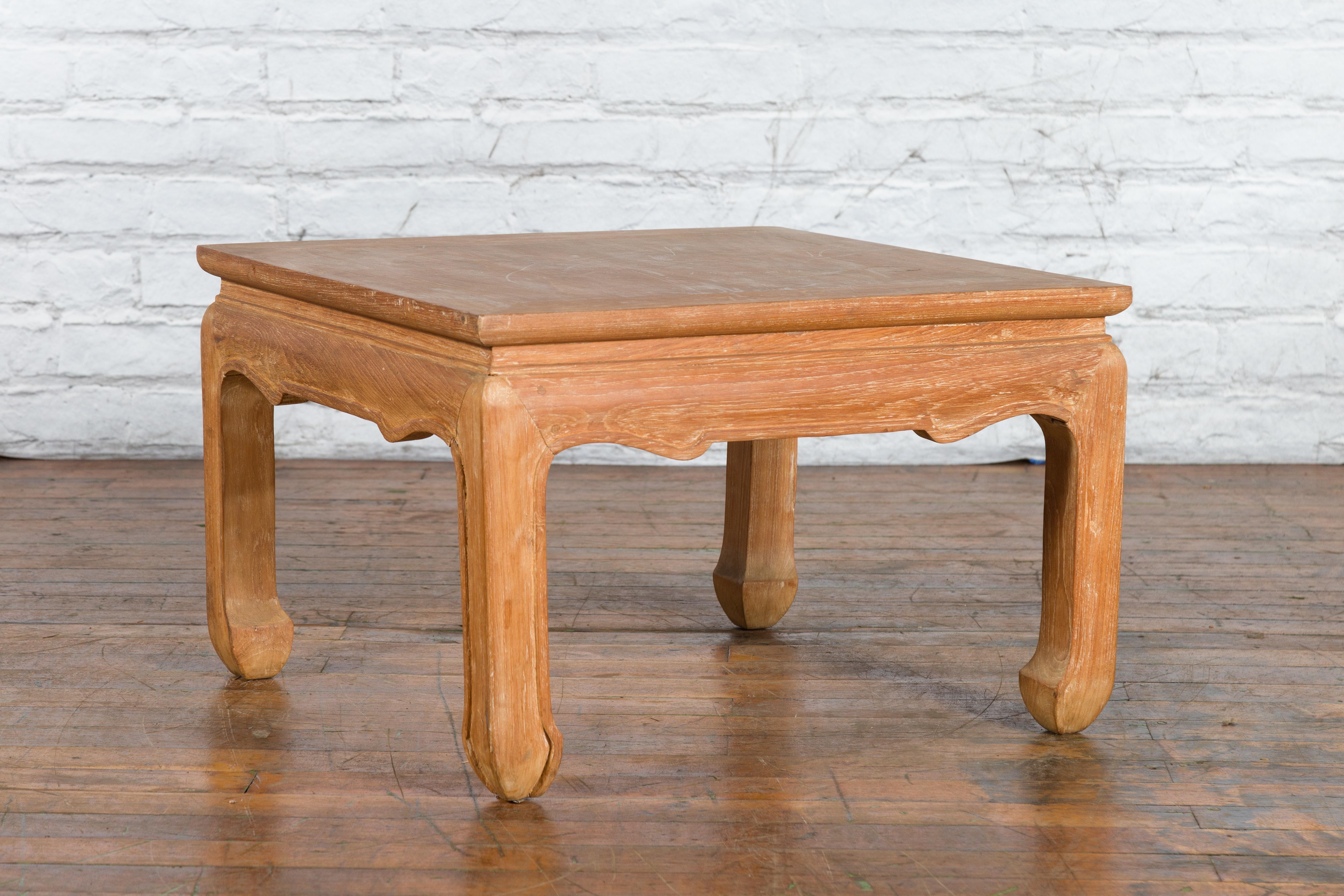 A vintage Ming Dynasty style Thai teak wood low drinks table from the mid-20th century with natural patina, carved apron and horse hoof extremities. Created in Thailand during the Midcentury period, this Chinese Ming Dynasty style teak wood drinks