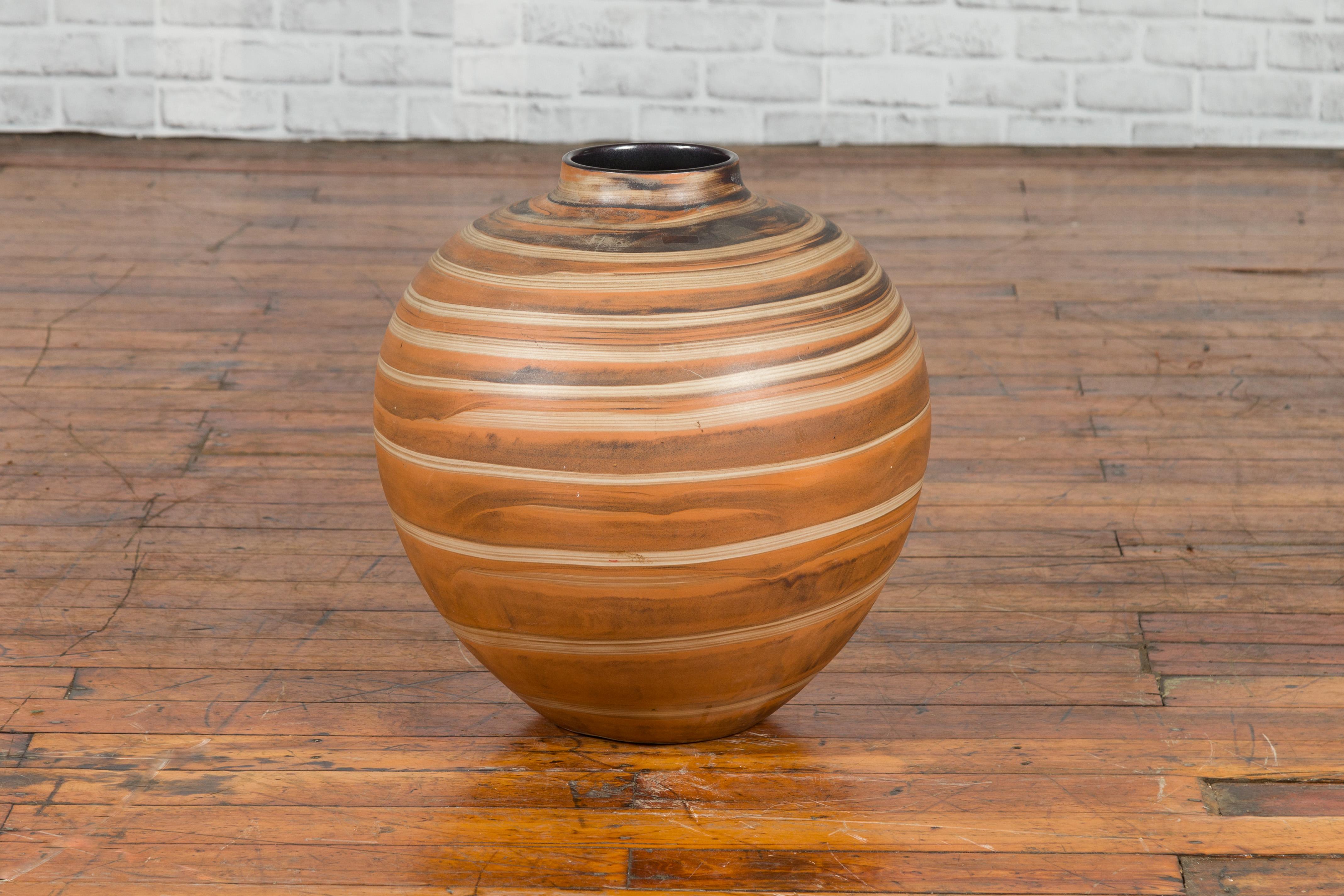 A vintage Thai Prem Collection jar from the mid-20th century from Chiang Mai with spiral decor. Created in Chiang Mai during the midcentury period, this vintage jar draws our attention with its spiral decor whose lighter hue contrasts beautifully