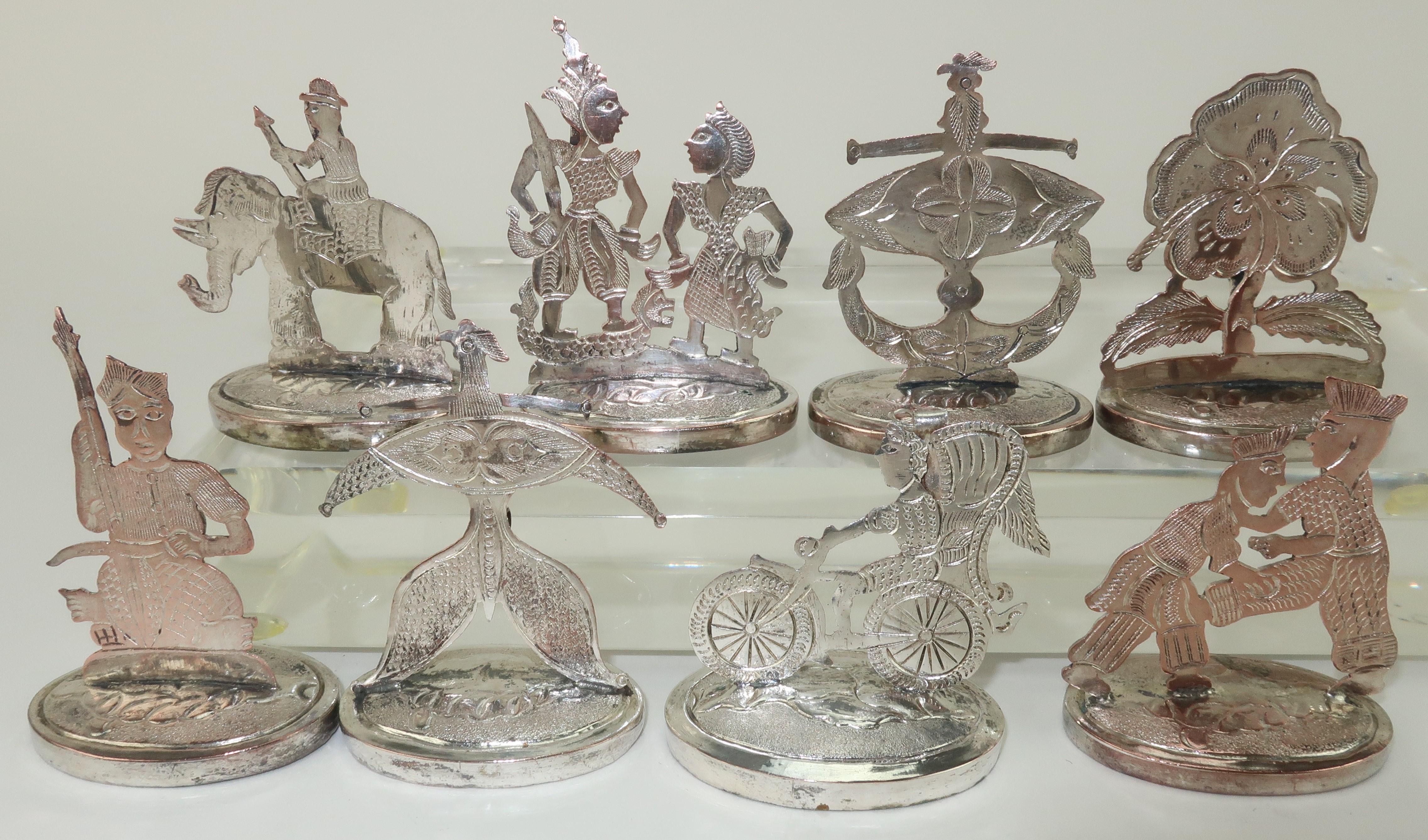 Set of 8 Thai silver figurative place card holders. The holders are hallmarked at the back but appear to be plate. They are beautifully detailed and offer exotic silhouettes with traditional Thai themes. Each holder is outfitted at the back with a