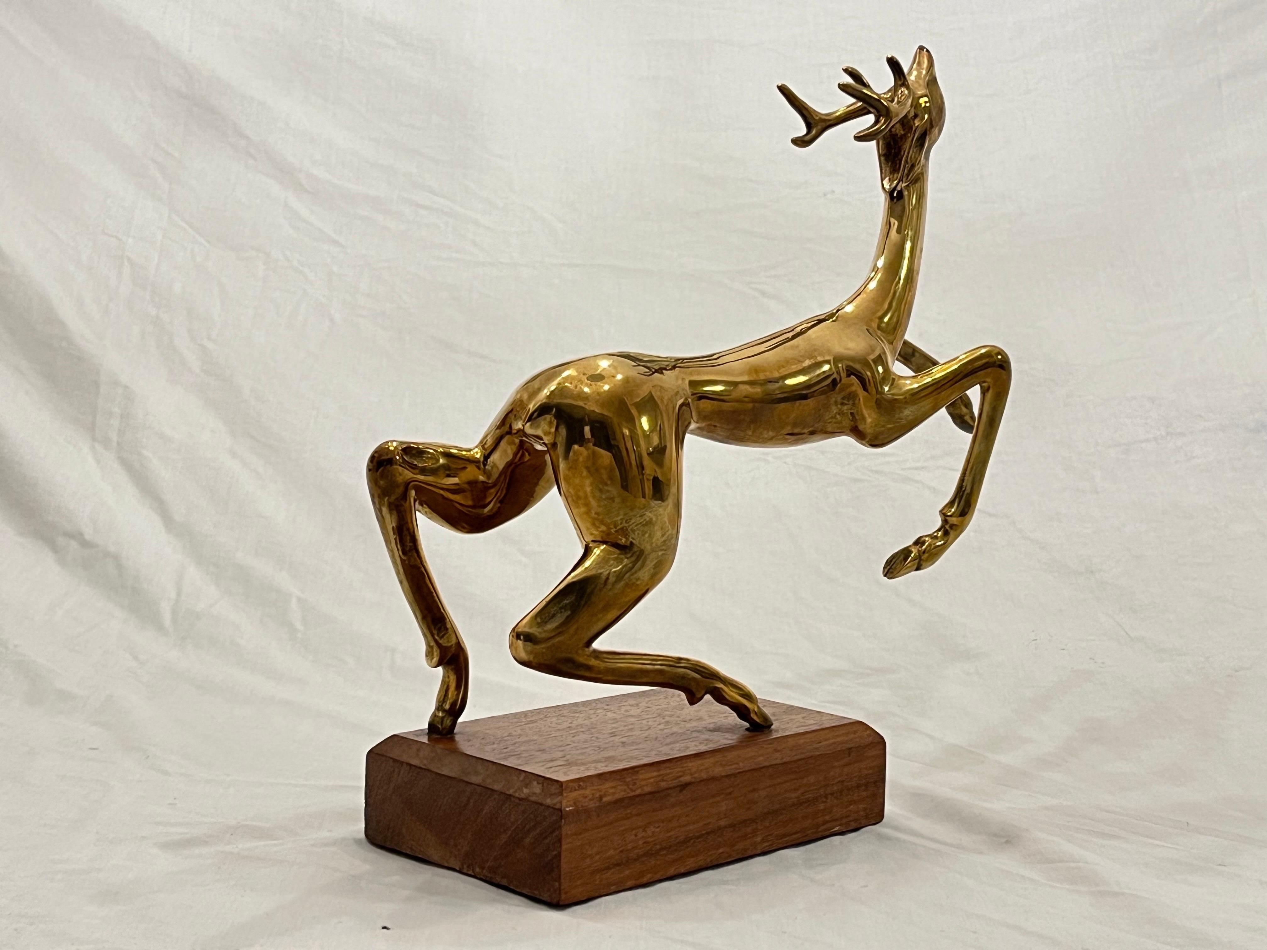 A vintage, circa 1970's, late 20th century solid bronze abstract animal sculpture by Hattakitkosol Somchai (1934 - 2000). This sculpture depicts a fluid, leaping deer or reindeer with antlers. The work is signed Somchai and the edition number A15 /