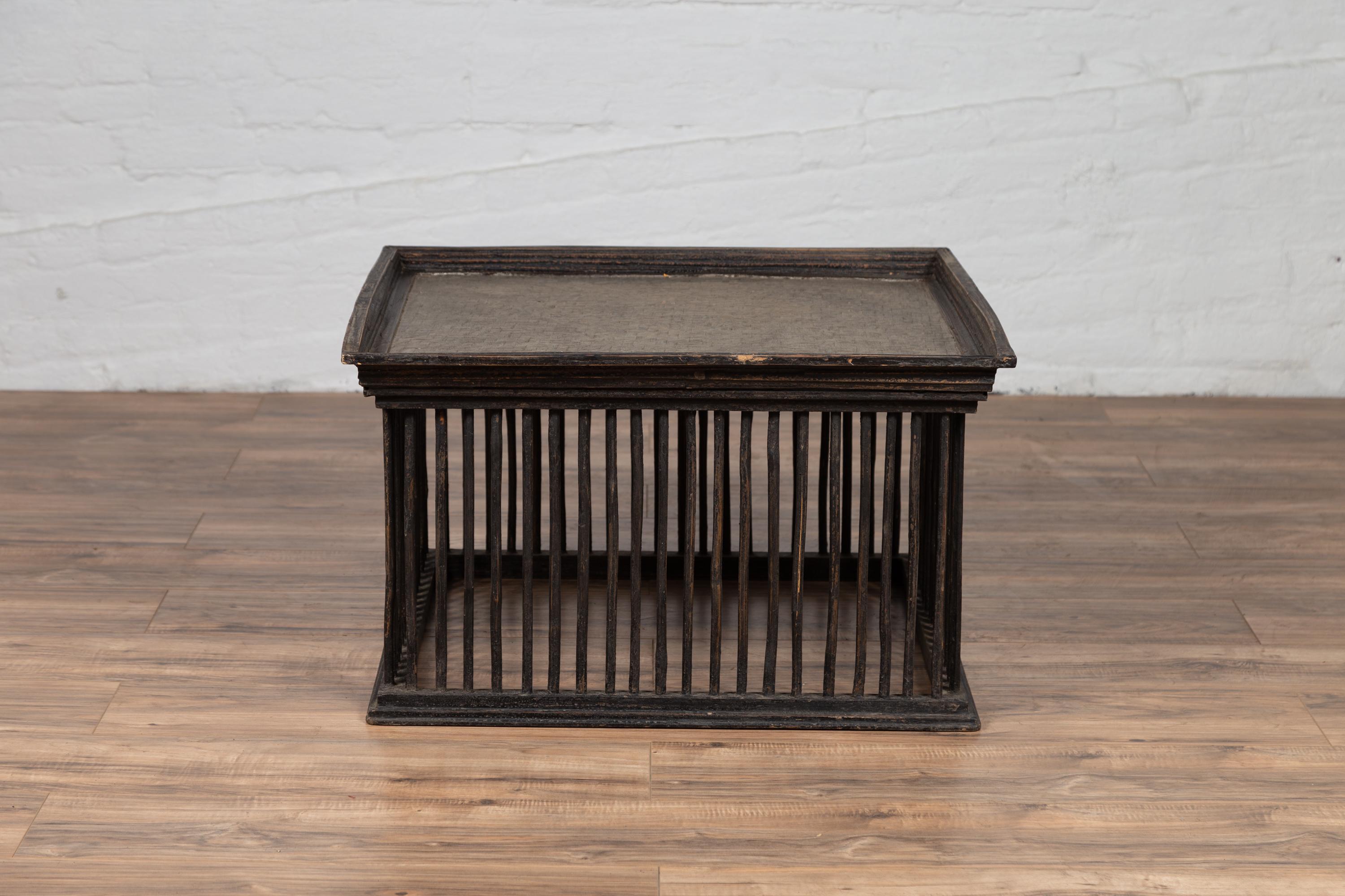 A vintage Thai square-shaped rattan coffee table from the mid-20th century, with silver leaf top and spindle design. We currently have two available, priced and sold individually. Born in Thailand during the mid-century period, this charming rattan