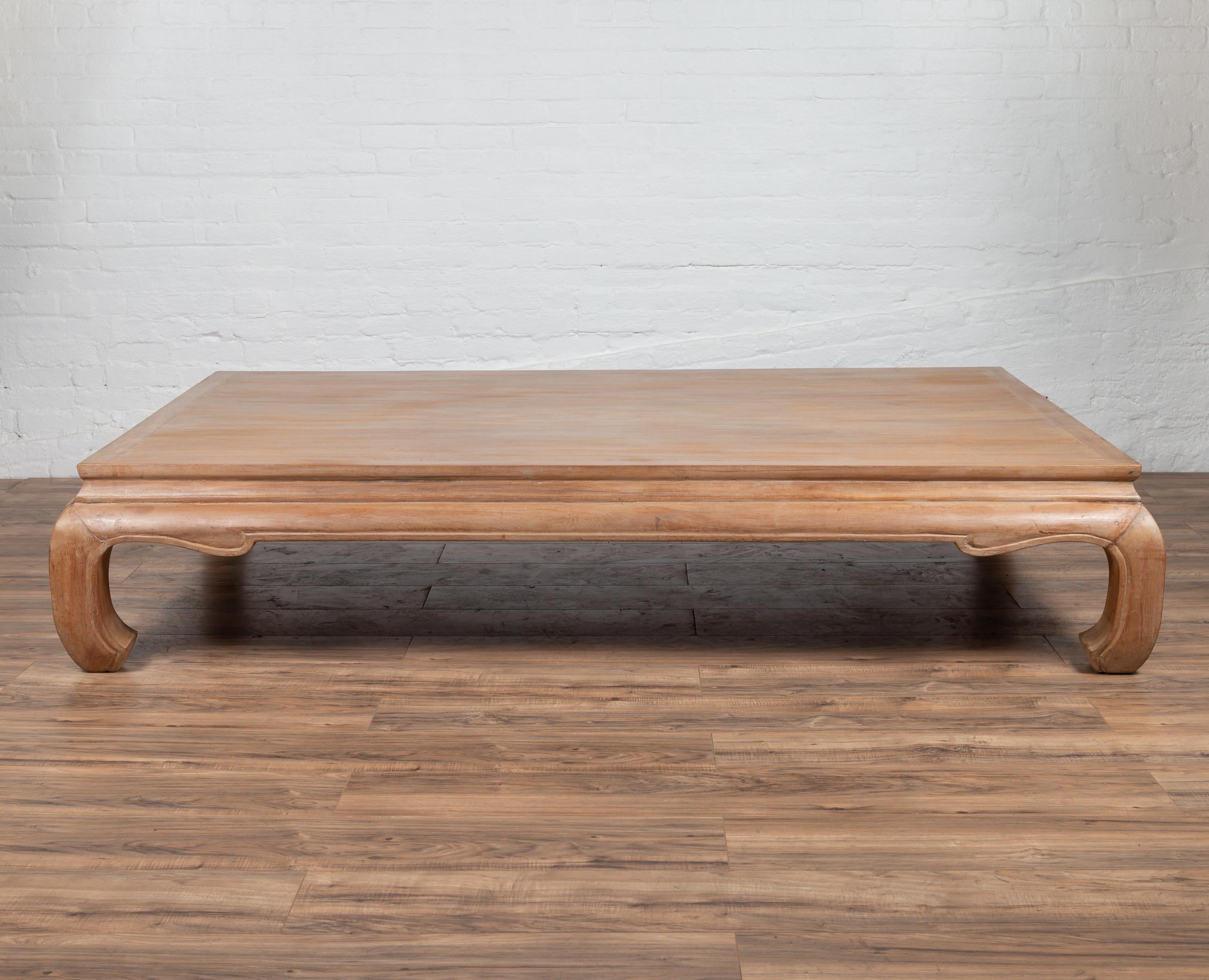 A vintage Thai teak wood coffee table from the late 20th century, with white wash finish and bulging chow legs. Born in Thailand, this elegant teak wood coffee table features a rectangular top sitting above a waisted apron with curving accents, the