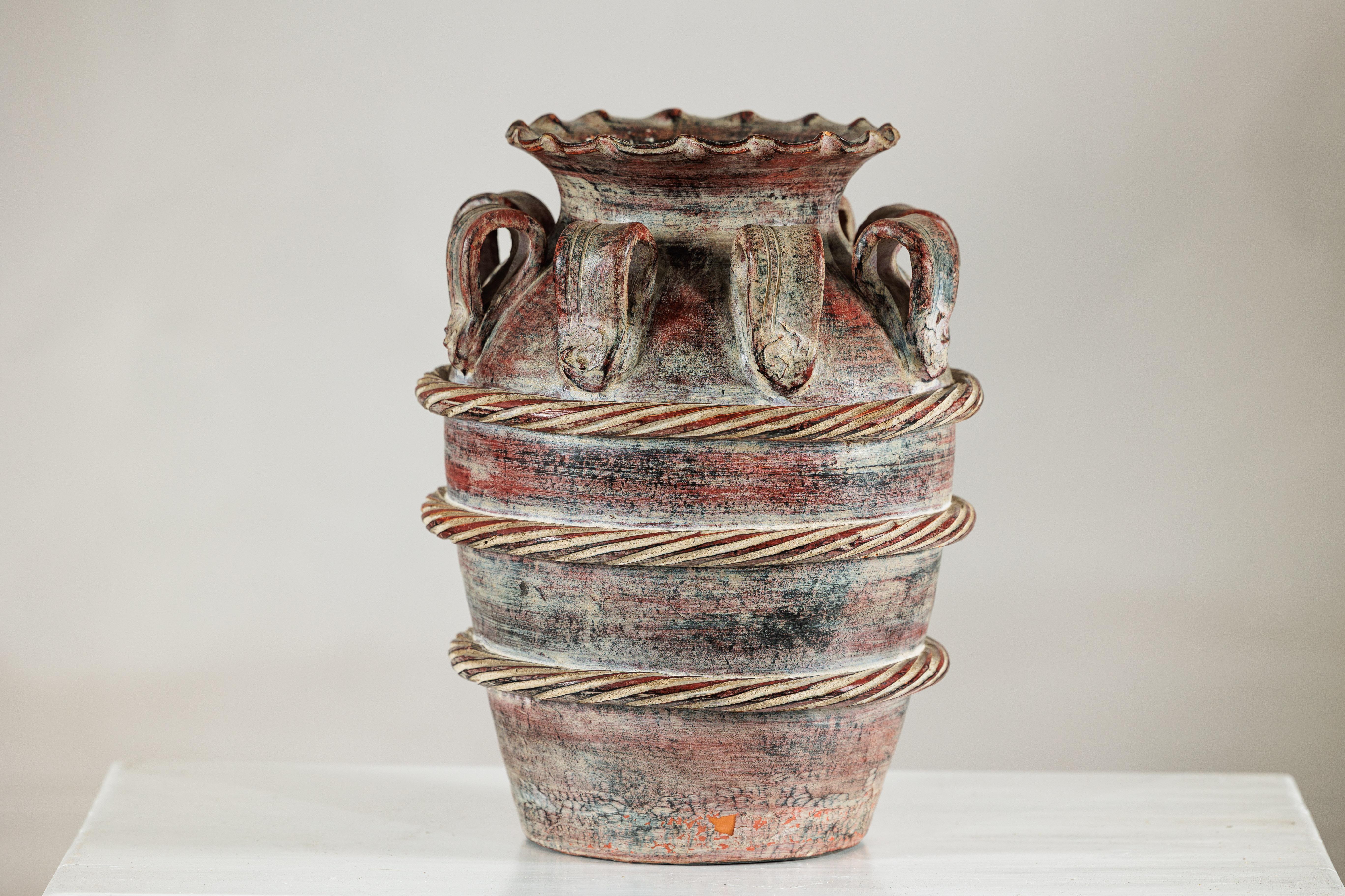 Un vaso d'acqua thailandese vintage che si distingue per la sua forma scultorea e gli ornamenti in corda. Il vaso, con un corpo largo che si assottiglia verso la base, è circondato da bande applicate e ritorte che salgono a spirale verso l'alto,