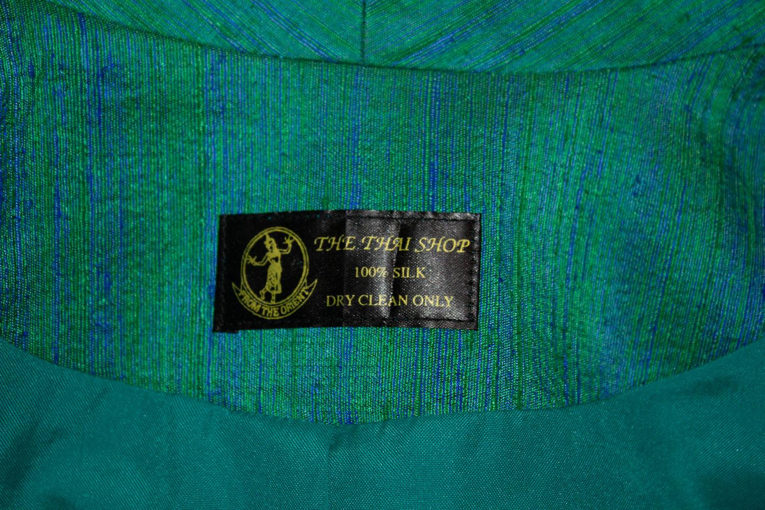 A stunning vintage silk jacket by The Thai Shop. In a wonderful green and blue colour, the jacket is fully lined and in excellent condition. It doesn't have a fastening but this could be easily added.
Measurements: shoulder to shoulder 17'', bust up
