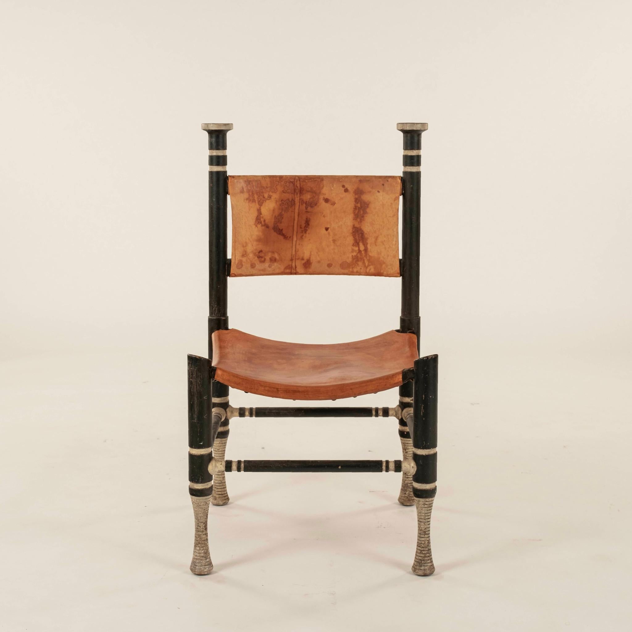 La sedia in stile Thebes degli anni '70 è composta da una struttura in legno verniciato con seduta e schienale in pelle. 