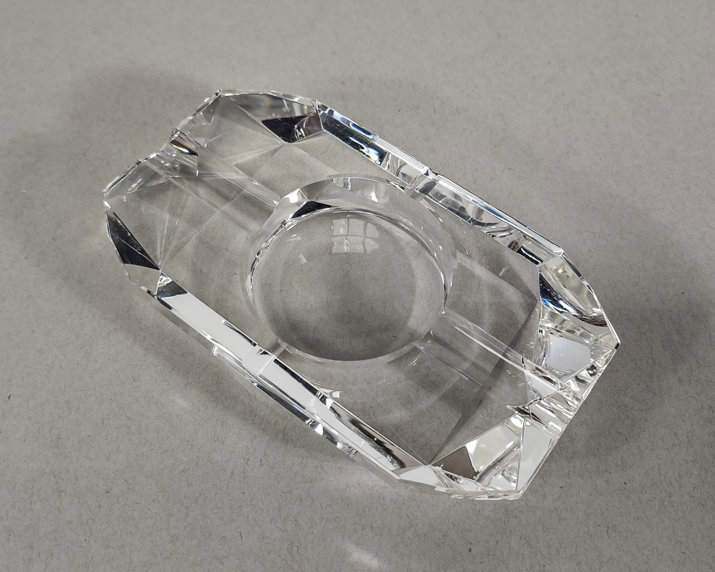 Vintage low thick clear glass ashtray. Beautiful facets that make this piece shine in different lightings. Divots for cigarettes on each side. No chips but some scratches are present.

4