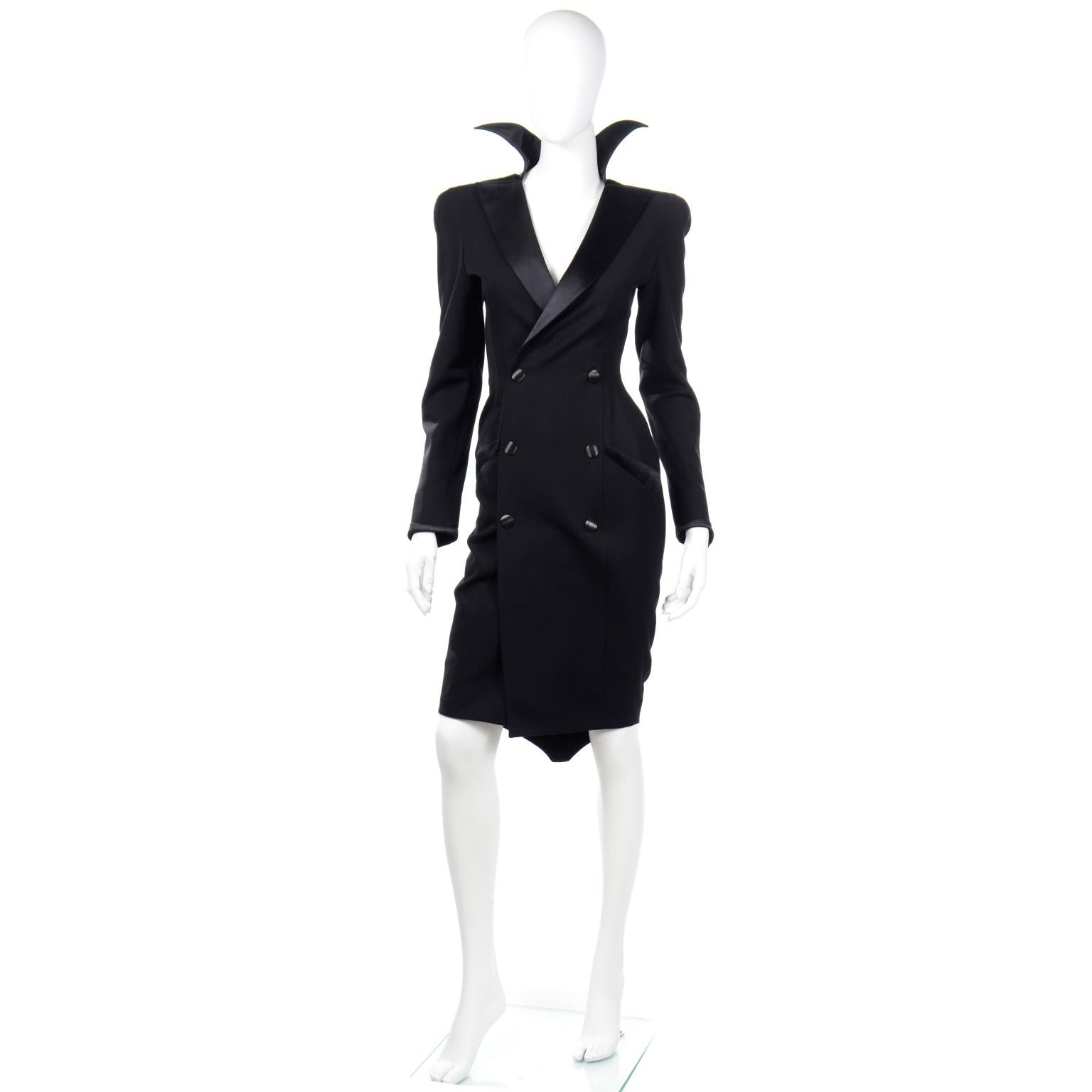 This is an ultra dramatic vintage Thierry Mugler coat or coat dress in a black combed wool crepe with black satin trim. We especially love the Cruella deVille style stand up collar! The dress is double breasted with large black decorative buttons
