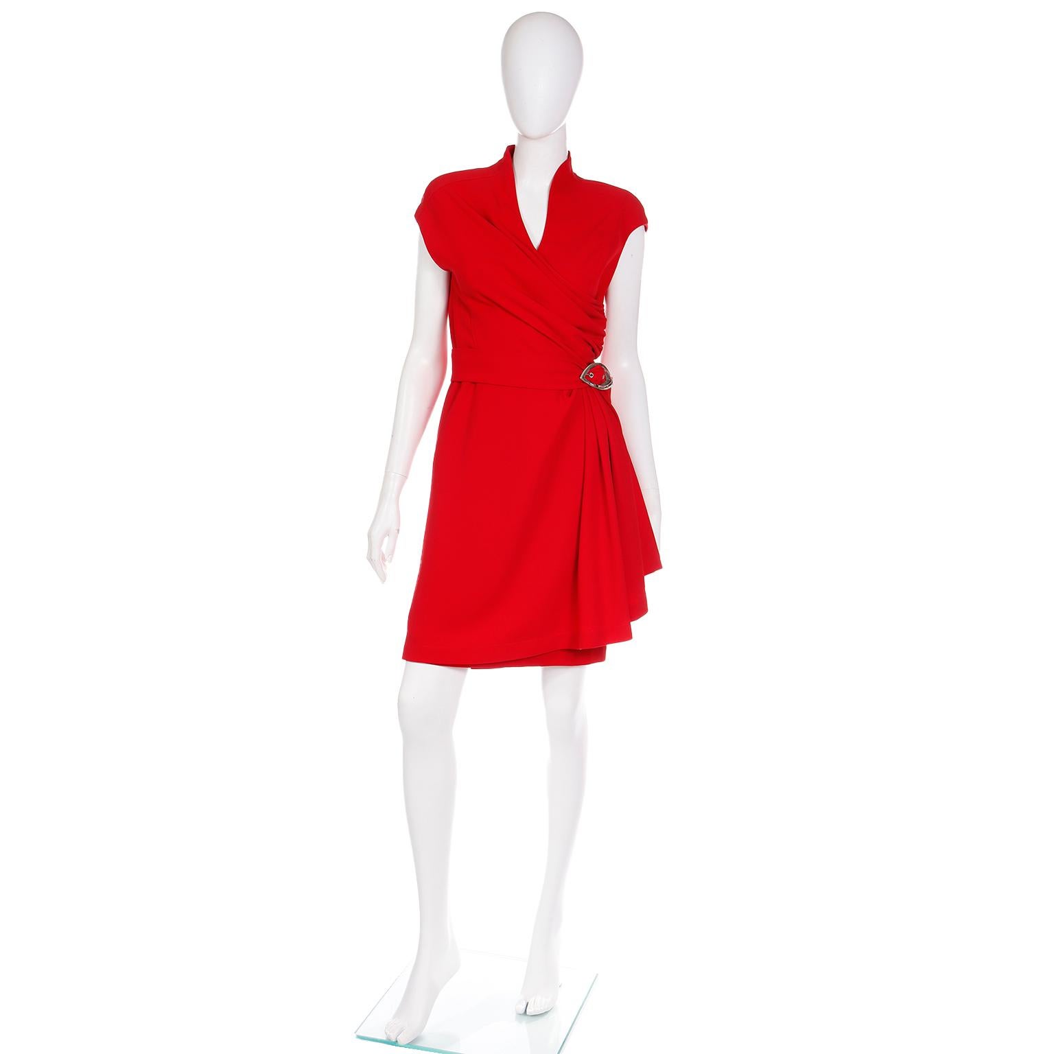 This is a fabulous cherry red Thierry Mugler wrap dress with a connected belt. This incredible vintage dress is fully lined and has a collar, shoulder pads, and a pretty silver signature 1990's Mugler buckle at the asymmetrical gathered waist