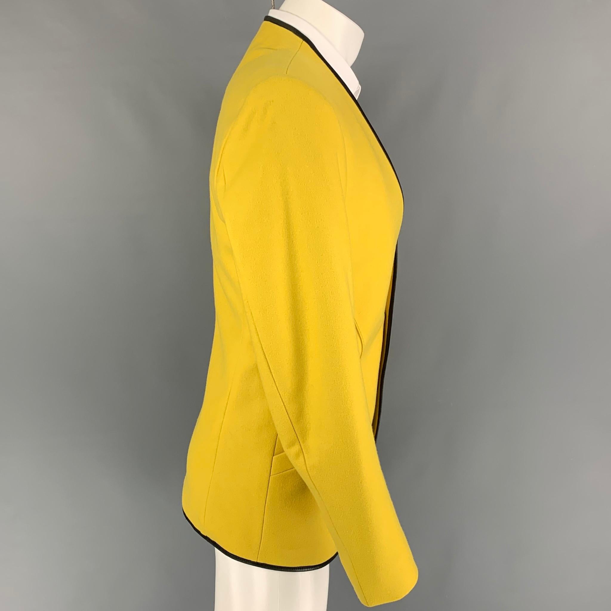 Vintage THIERRY MUGLER jacket comes in a yellow wool with a full liner featuring a collarless style, leather trim, silver tone stat buttons, front pockets, and a double snap button closure. Made in France. 

Very Good Pre-Owned Condition.
Marked: