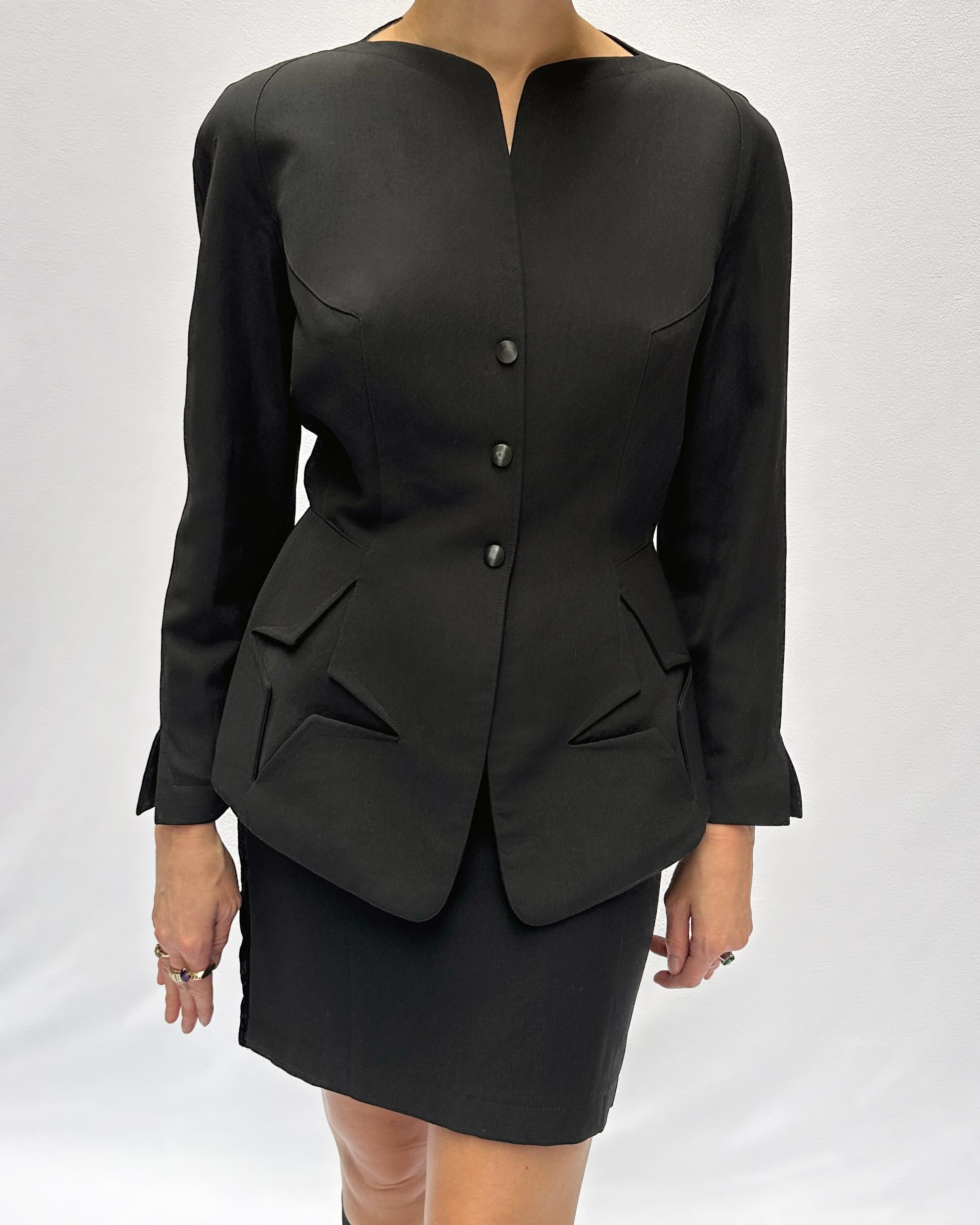 This vintage Thierry Mugler skirt suit (circa 1990) is instantly recognizable by its unique star cut-out pockets, a signature Mugler emblem, incorporated in a design only he was clever enough to achieve. Thierry Mugler and his work have been the
