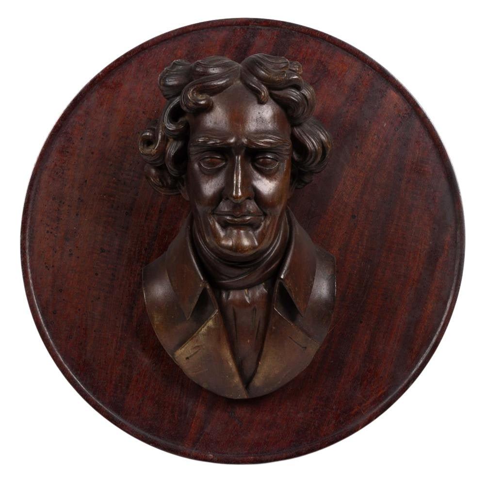 Vorgestellt wird eine geschnitzte Holzbüste von Thomas Jefferson, circa Anfang des 20. Jahrhunderts. Dies ist eine unglaublich detaillierte geschnitzte Darstellung des jungen Jefferson. Die büstenlange Schnitzerei ist an einer runden Holztafel