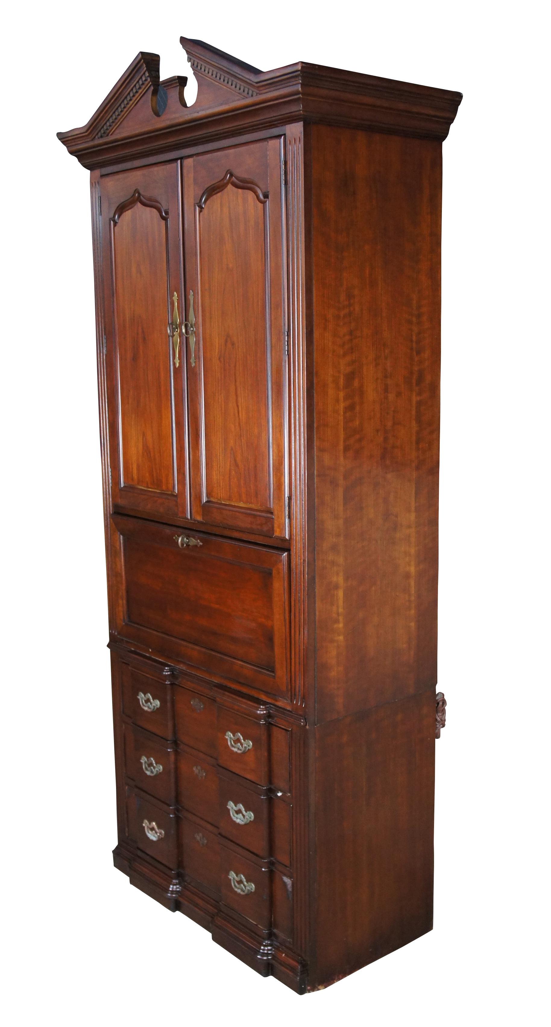 Traditional Thomasville blockfront secretary bookcase or dry bar, circa last quarter 20th century. Made from cherry with an illuminated laminate drop front work surface over three lower dovetailed drawers with brass hardware. Upper bookcase opens to