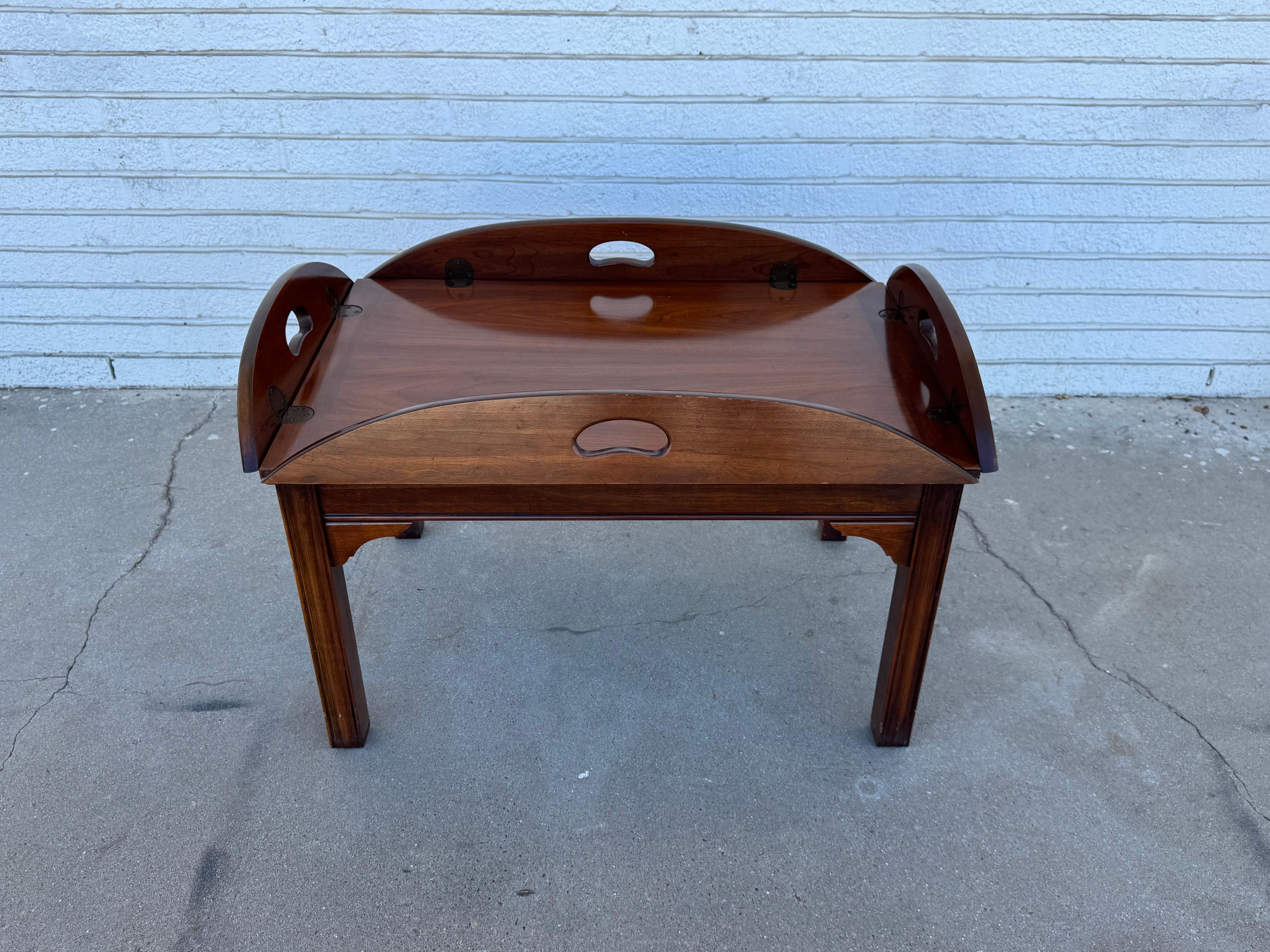 This is an unconventional styled coffee table.
It features 4 small drop leaves on each side.
It's made of a nicely grained mahogany and would make a nice addition to any room.