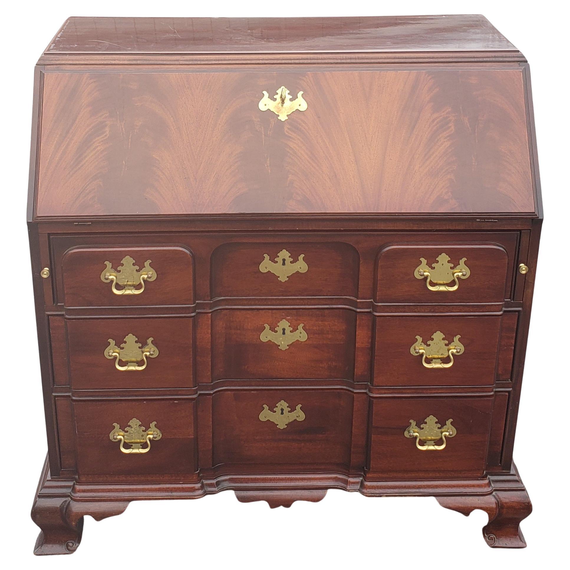 This Georgian style traditional block front secretary desk is matched flame grain mahogany is signed Thomasville 
Original finish in fine condition.
Brass hardware is original and heavy weight, drawers have solid oak sides. The drop front rests on