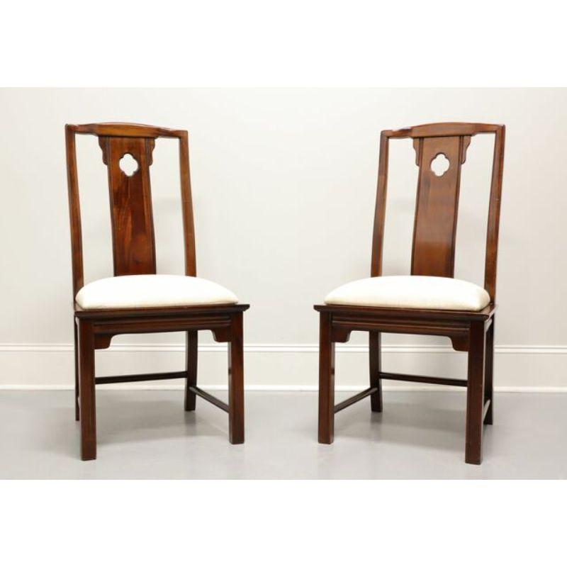 A pair of Asian inspired dining side chairs by Thomasville. Solid mahogany with upholstered seats in an Asian patterned cream fabric. Features carved center backs, Asian style apron, legs and feet with back and side stretchers. Made in the late 20th
