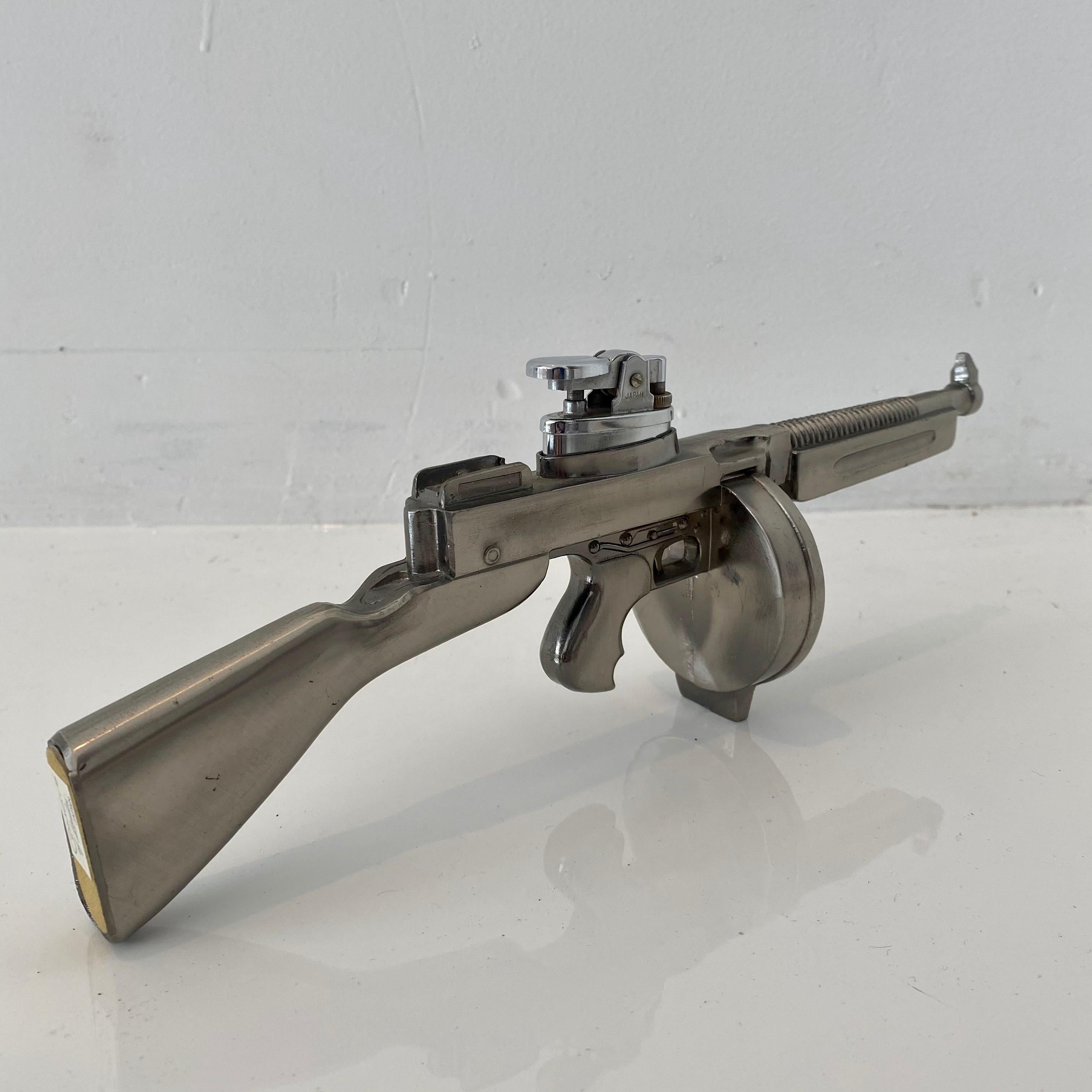 Cool vintage table lighter in the shape of a Thompson M1921 machine gun. Made of metal. Label at bottom reads 