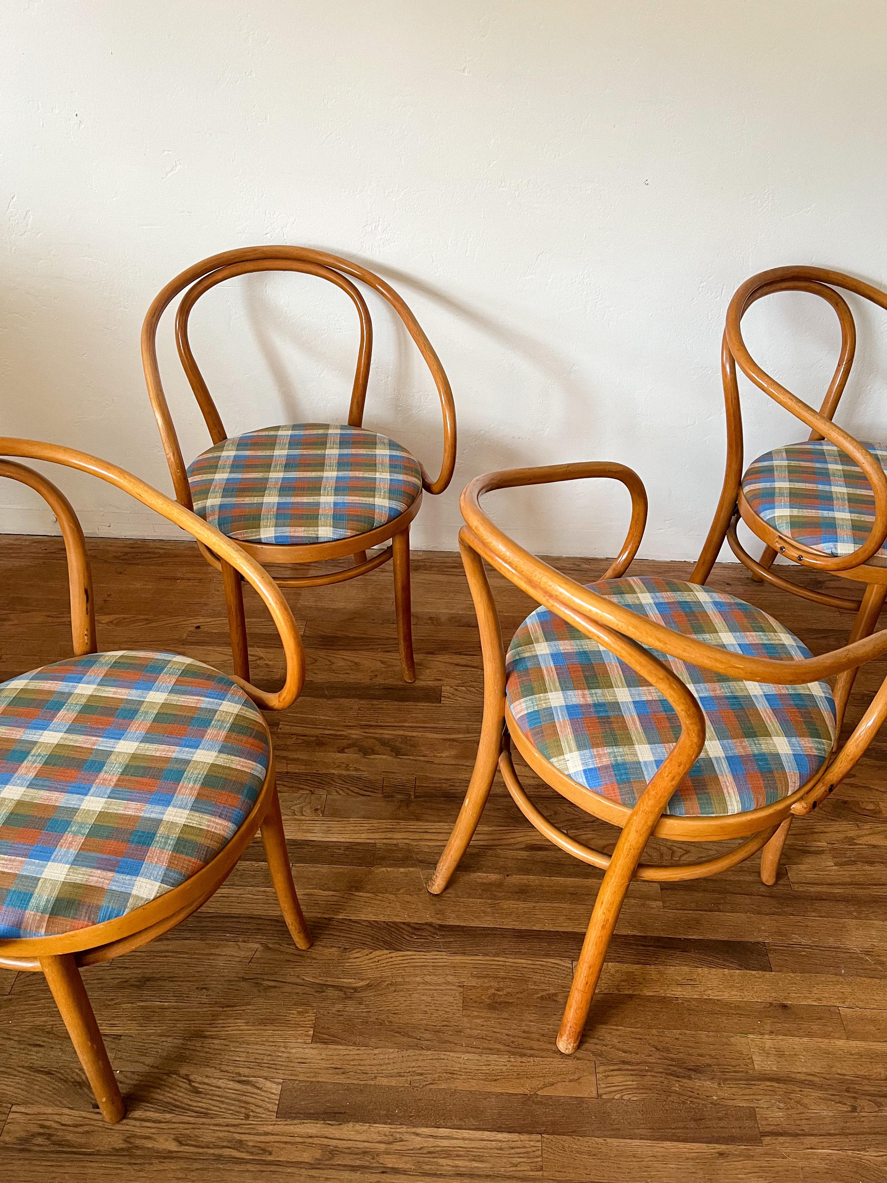 Ein Satz von vier originalen Thonet Bugholz-Esszimmerstühlen, etwa Mitte des 20. Jahrhunderts, mit den ikonischen geschwungenen Buchenholzrahmen und runden Sitzen, die die modernistische Eleganz der Marke definierten.

Jeder Stuhl wurde mit einem
