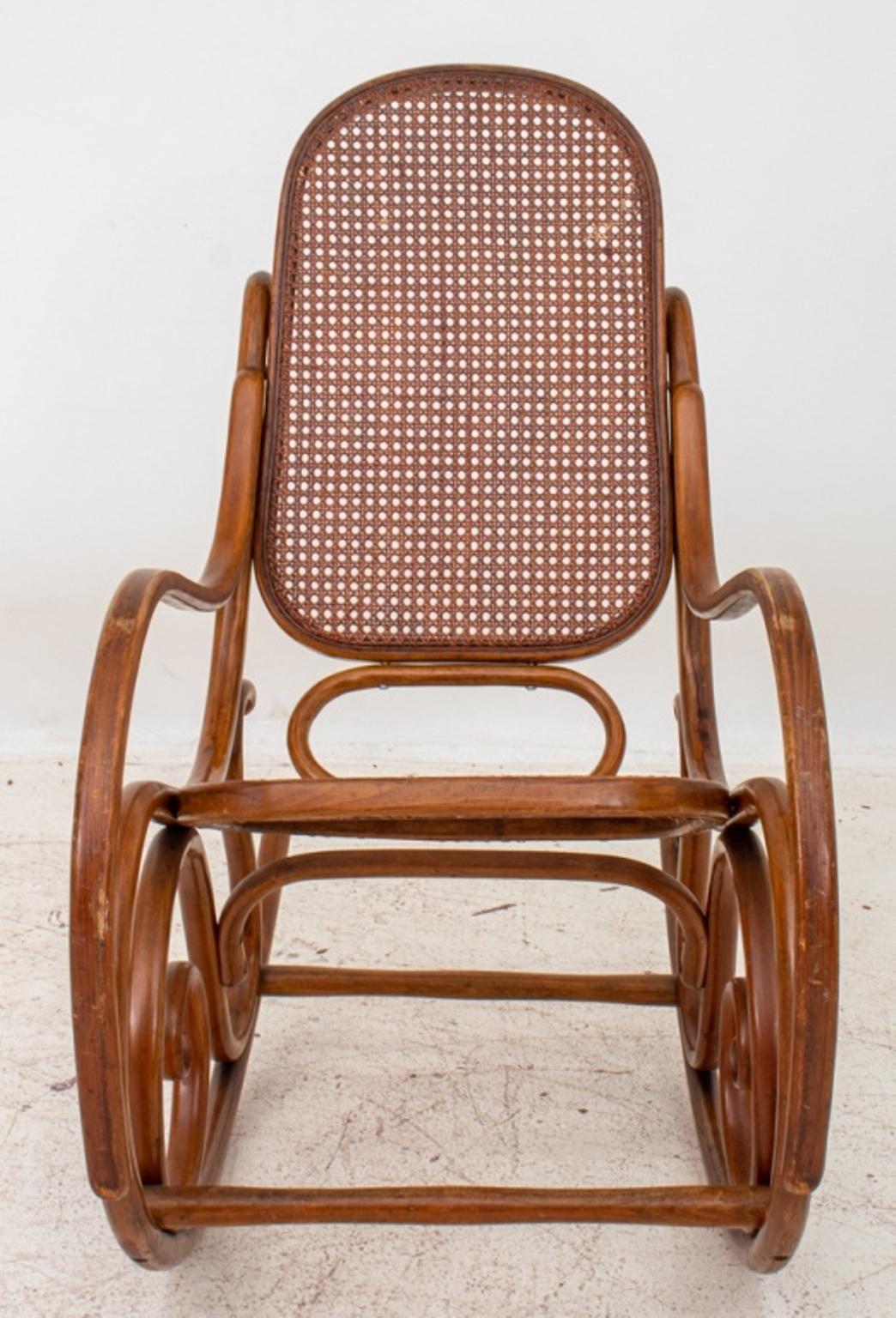 Vintage Thonet Bentwood and caned rocking chair, Model No. 21, with oval back and seat conjoined by scrolling bentwood elements. 44