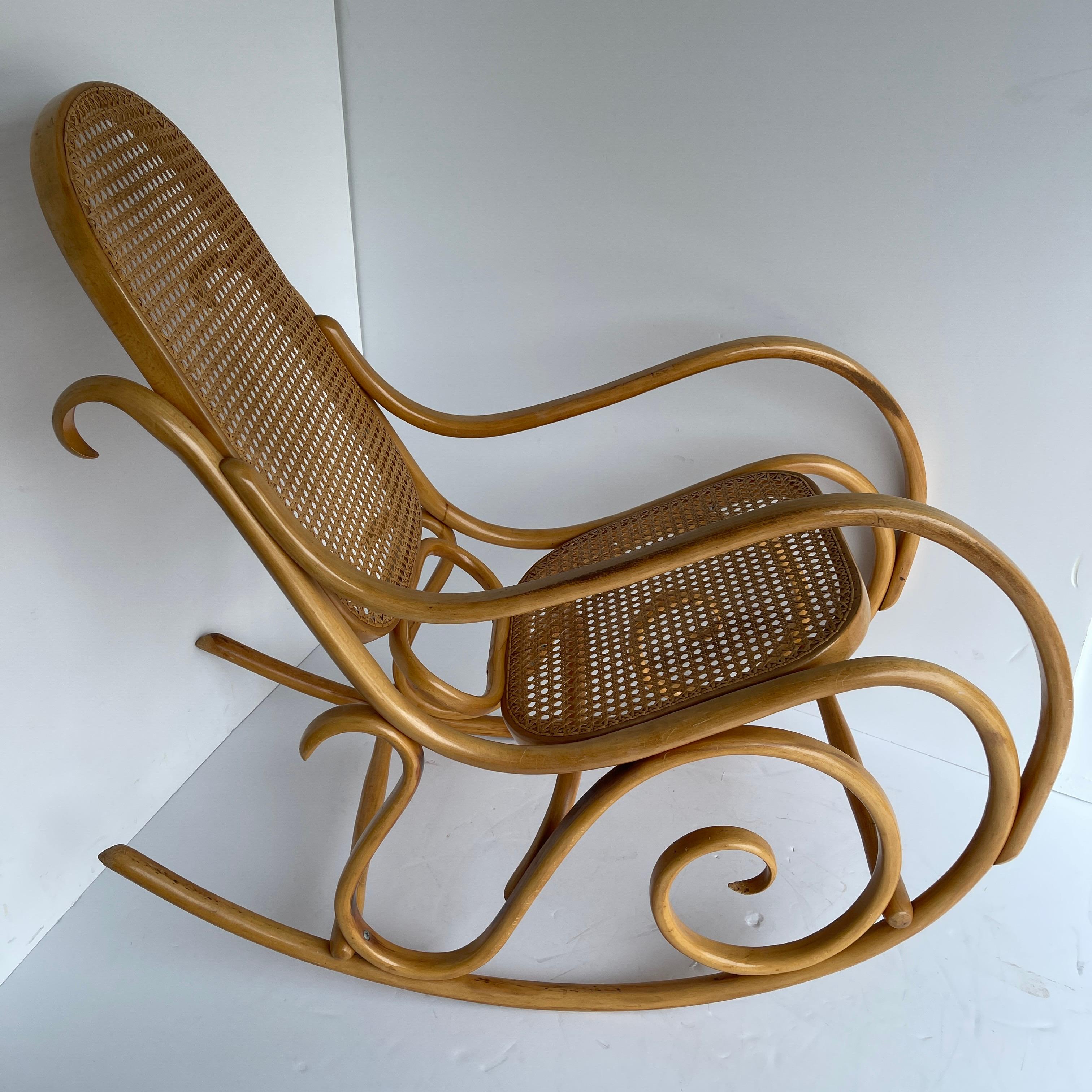 Late 20th century Thonet Schaukelstuhl rocking chair, made in Austria
Mid-Century Modern Thonet bentwood and cane rocking chair. This beautiful and graceful rocking chair features cane back and seat, bentwood frame. Michael Thonet chose to present