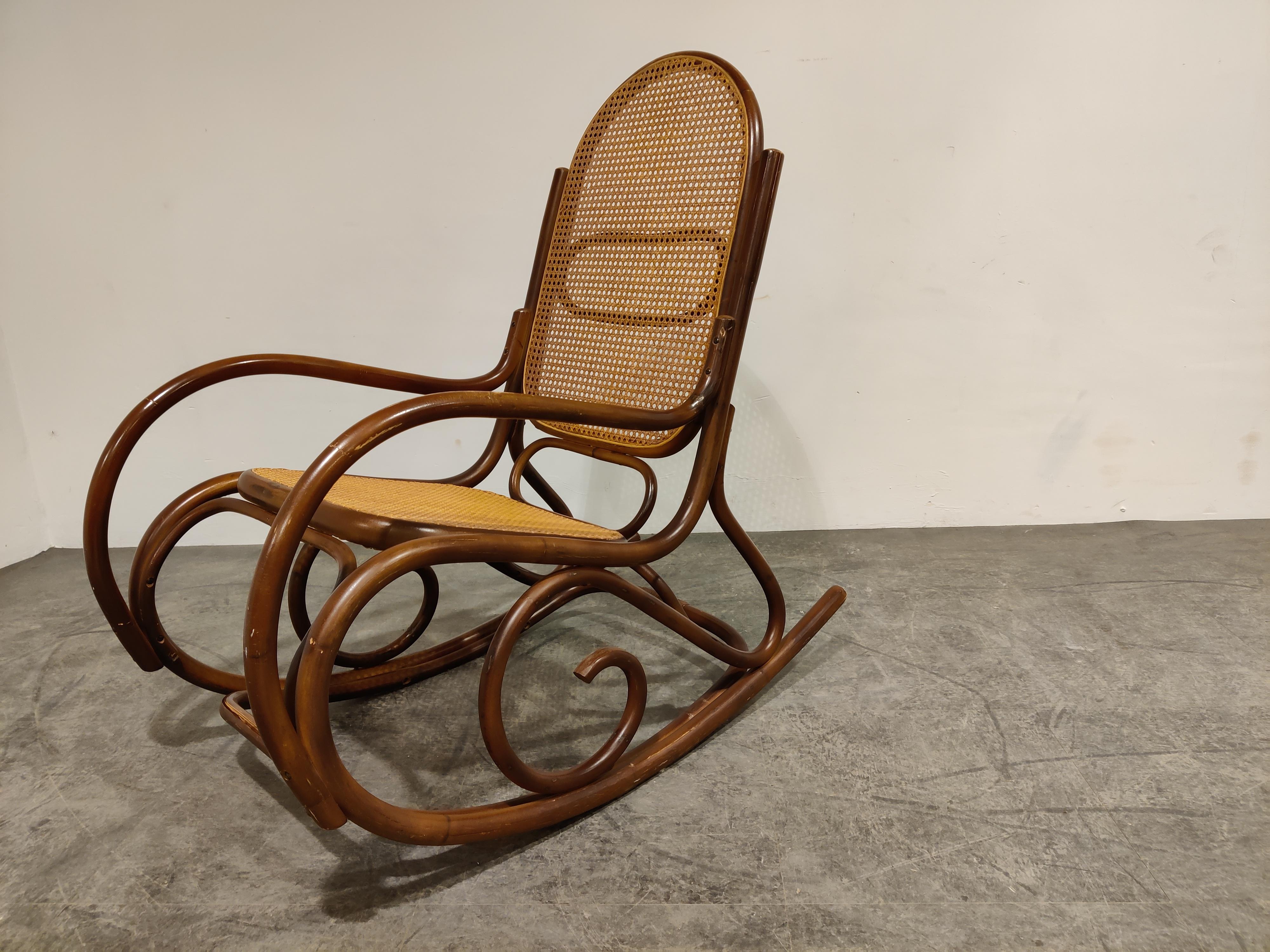 Note: The shown shipping rates are automatically generated by 1stdibs - this item needs a custom shipping quote, please contact us for delivery quotes.

Mid century bentwood and cane webbing rocking chair.

These thonet style rocking chair has a