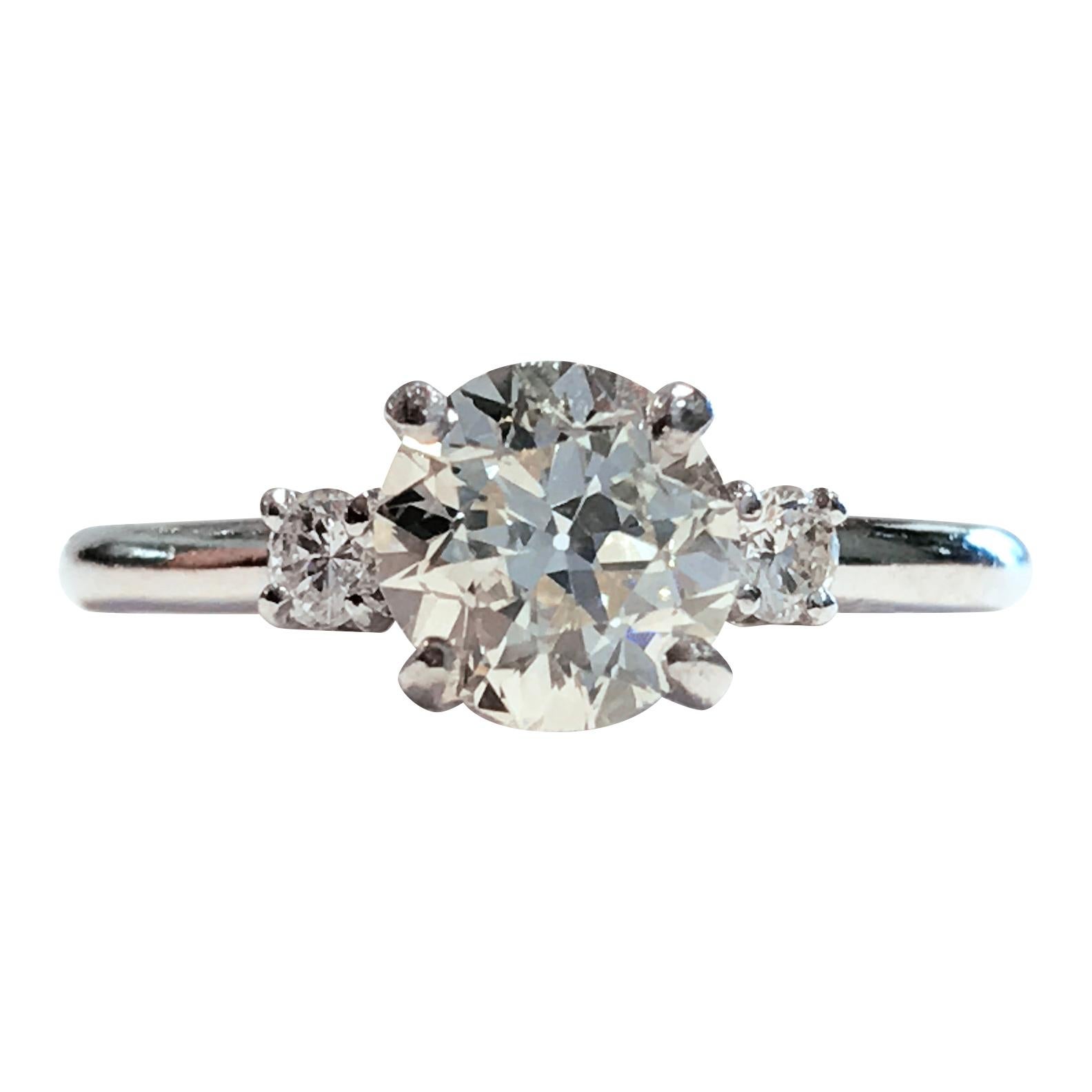 Vintage Platinum Three-Diamond Engagement Ring. Old Mine-cut Center Diamond, four-prong set. Center Diamond is SI1 in clarity (G.I.A.) and M-L in color (G.I.A.) measuring 6.28 x 6.33mm for a carat weight of 0.87ct. Two round side diamonds measure