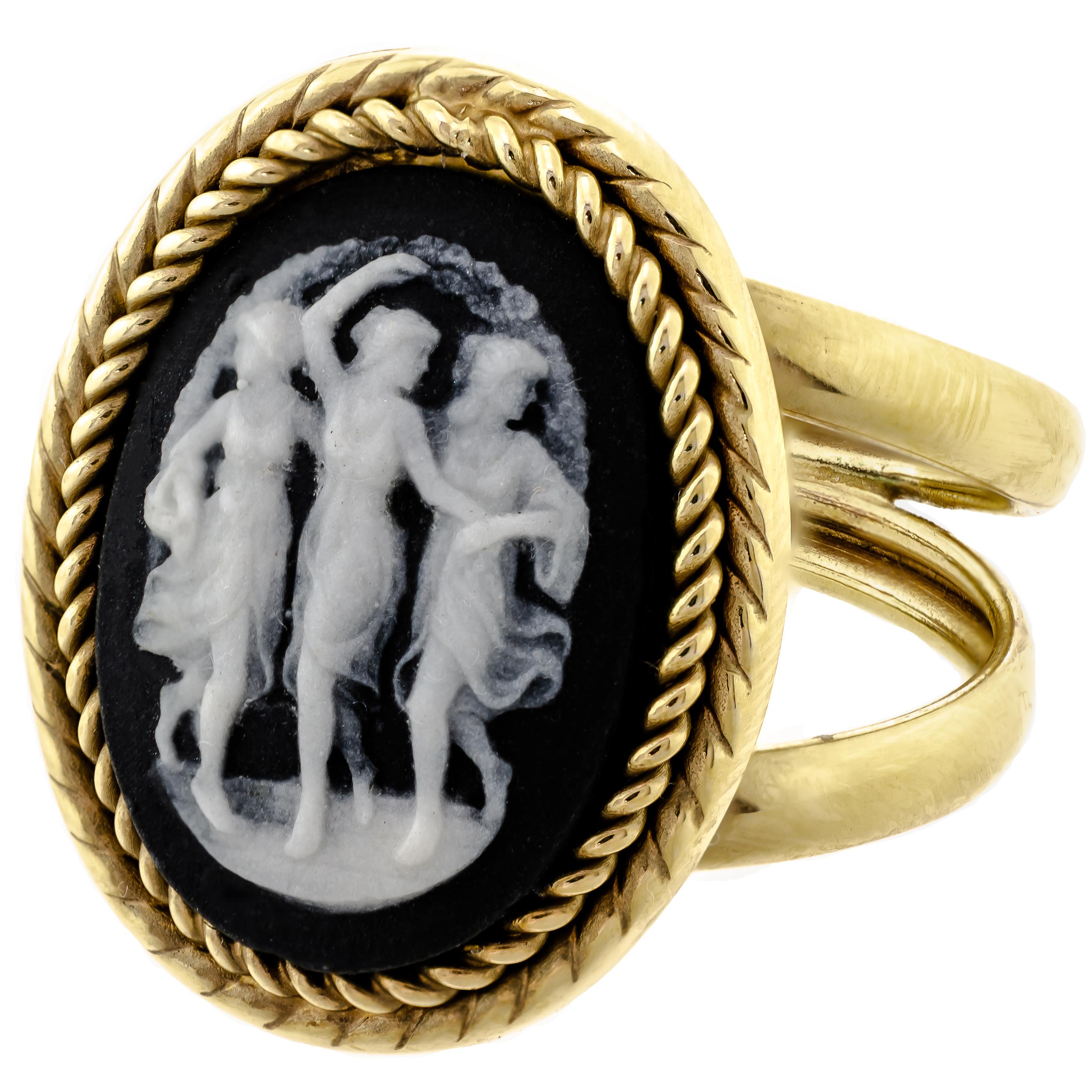 This charming vintage three graces black and white Wedgwood cameo of the oval shape measuring approximately 16.7mm by 12mm bezel set into a 14kt yellow gold twisted rope border double shank ring mount. Touchmarks 14kt, Italy, ZRW Maker's Mark in a
