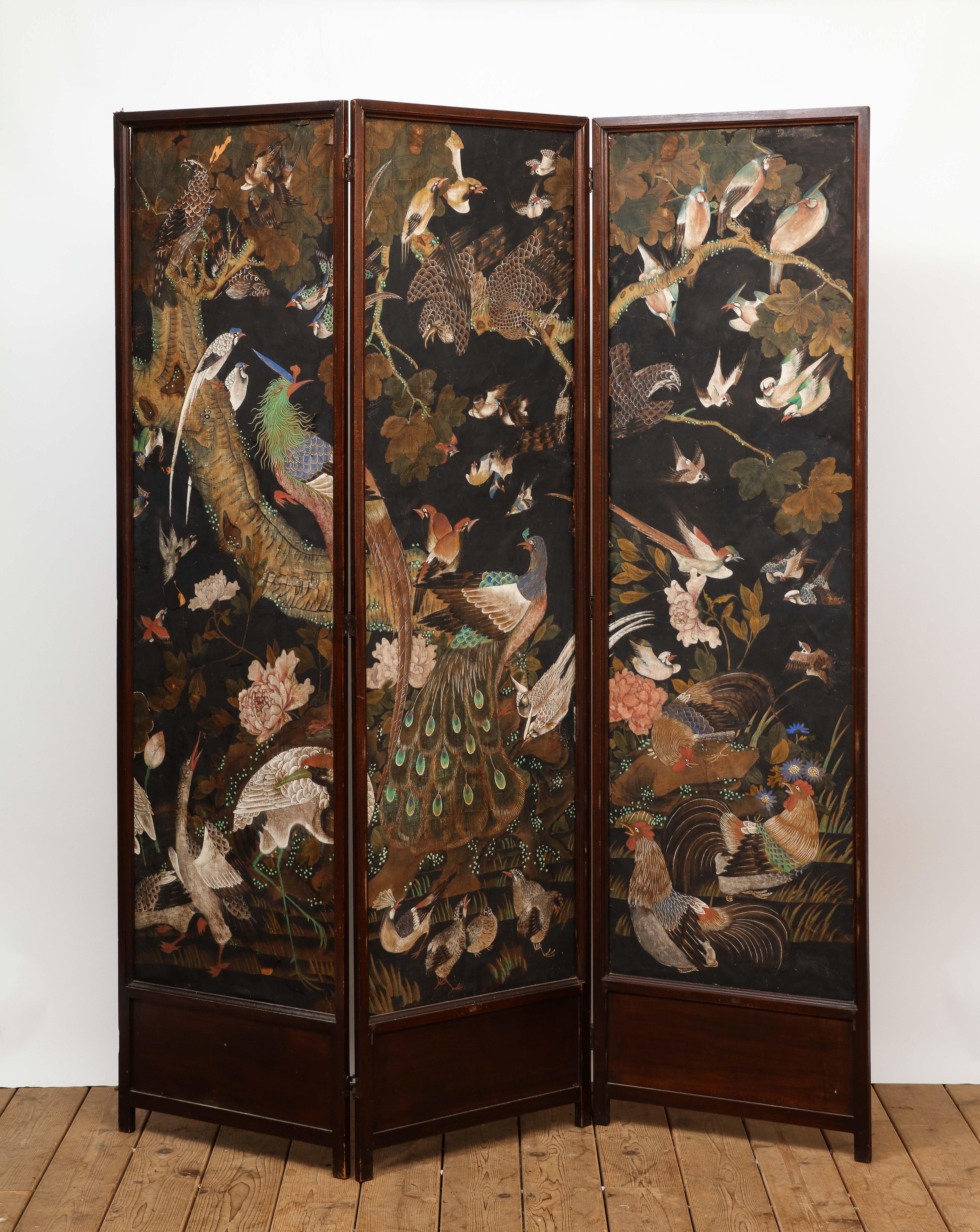 Vintage French three-panel folding screen featuring DeGournay hand-painted scenic wallpaper depicting various birds, including a central peacock, hens, swallows and hawks. The wood frame needs some restoration, the paper has small tears and