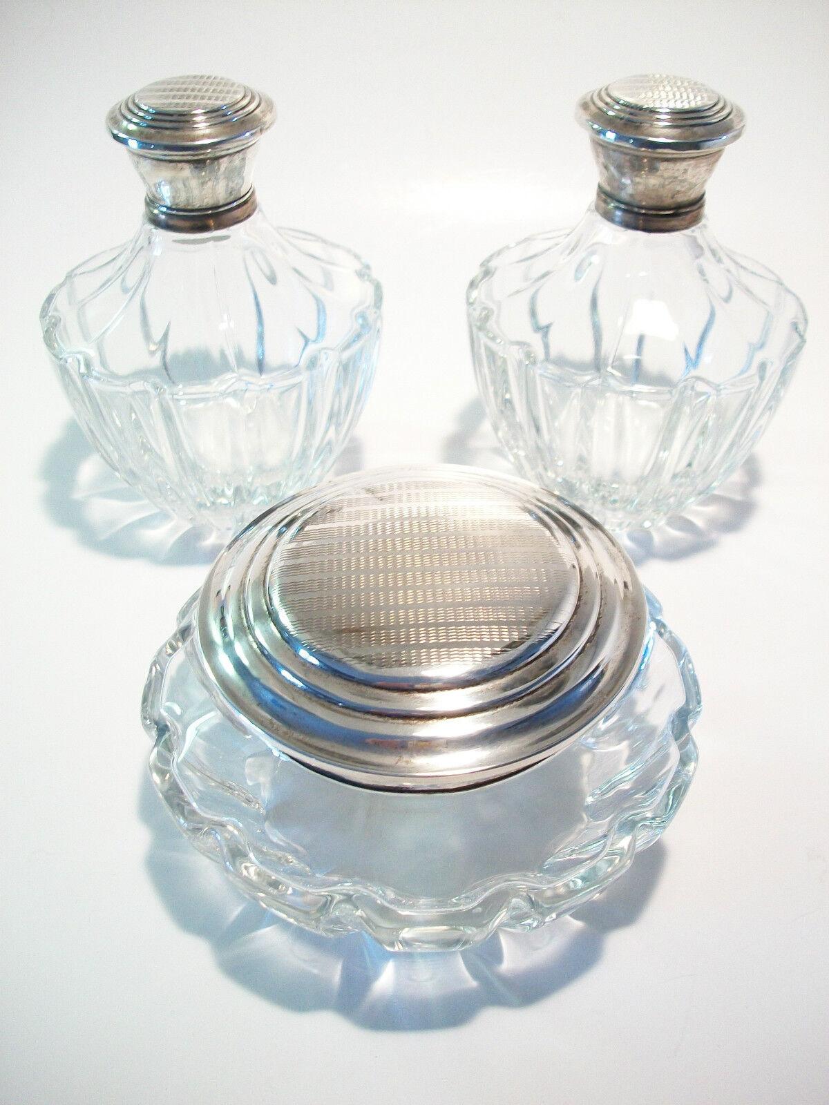 Vintage three piece crystal and silver plate vanity set - lidded powder bowl - two lidded bottles with stoppers for creams or lotions - machine tooled designs lids - each bottle with metal clad rim - unsigned - early 20th century.

Vintage Condition