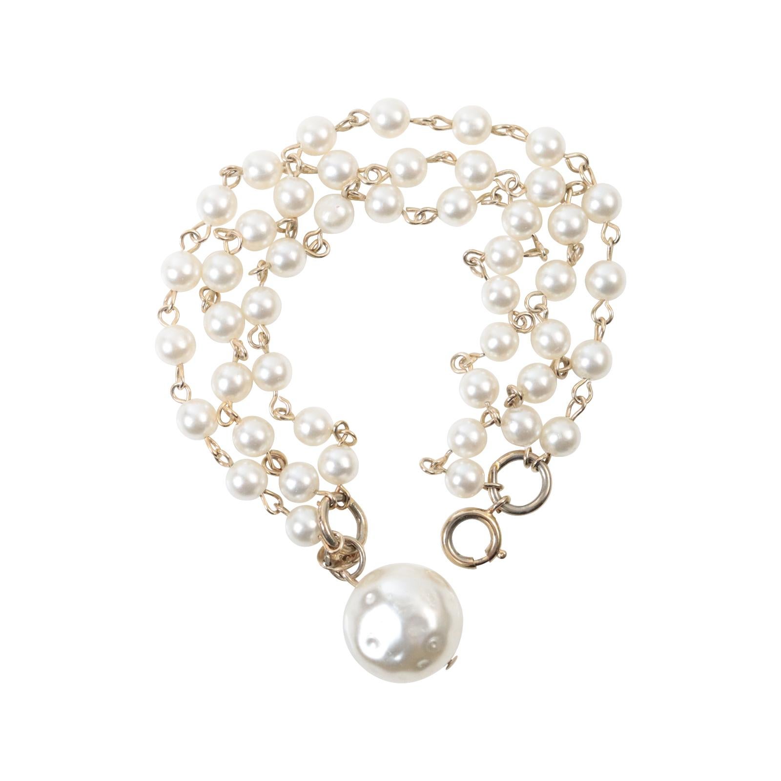 Vintage Three-Row Faux Pearl Dangling Bracelet Circa 1980s.  This is a bracelet that will never go out of style.  You can wear it for a black-tie event or to elevate your sweater, t-shirt, and jeans.  This is a Three-row faux pearl bracelet set in
