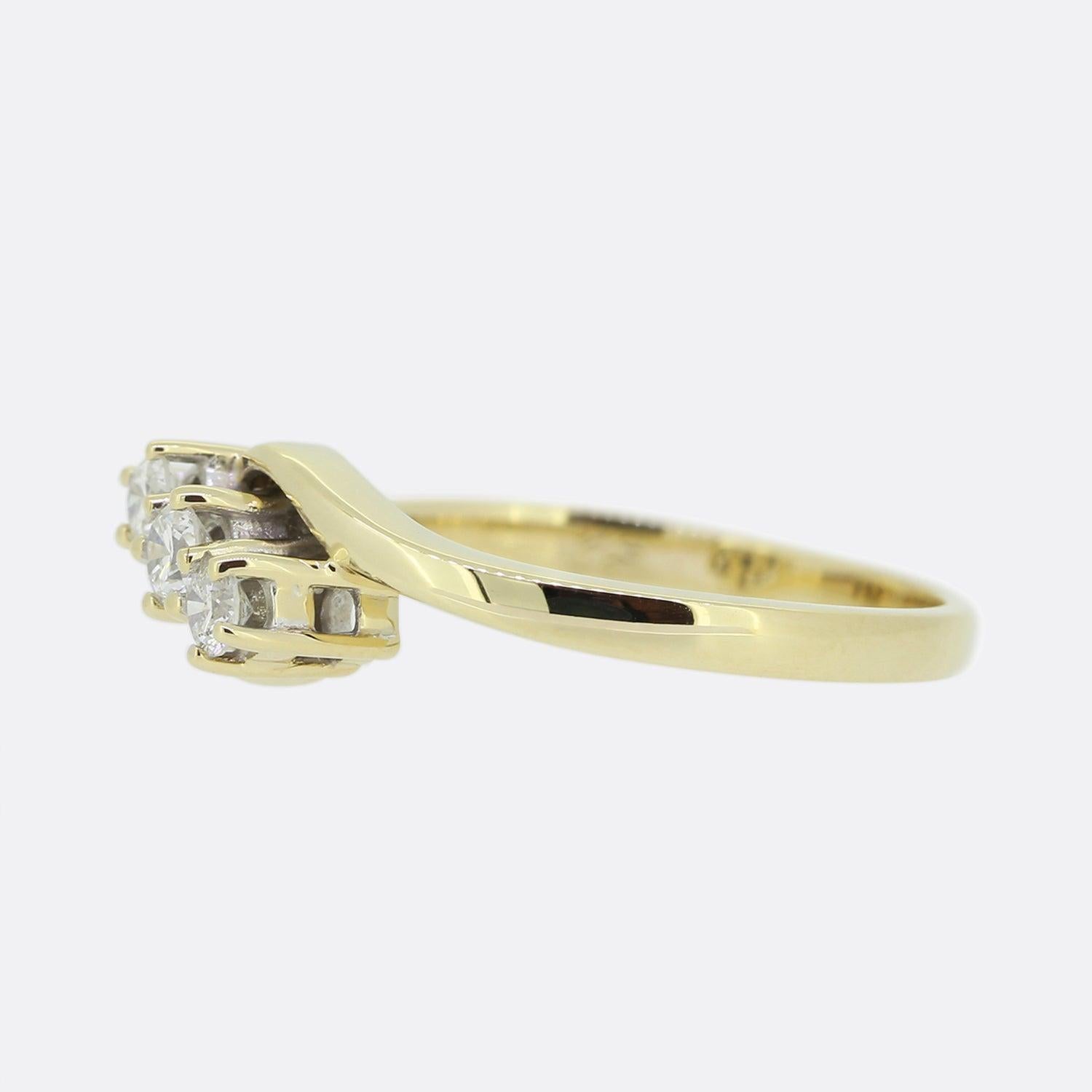 This is an 18ct yellow gold diamond three stone twist ring. The ring features three round brilliant cut diamonds which have been claw set at the centre of two elegant crossover bands. The diamonds are well matched for colour and clarity with the