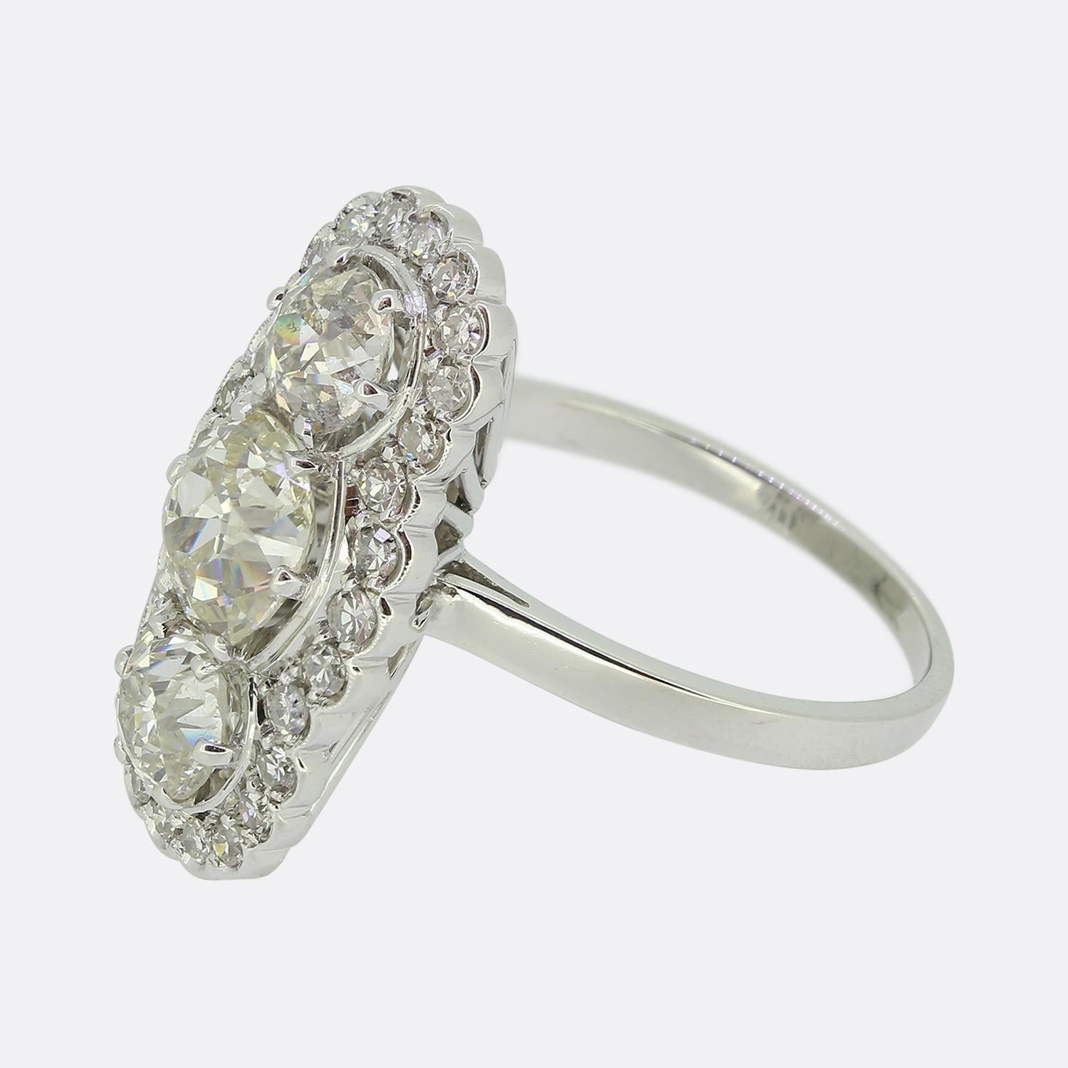 Here we have a fabulous three-stone diamond cluster ring from the Edwardian era. This antique piece has been crafted from 18ct white gold and features an impressive trio of chunky round faceted old cut diamonds; the largest of which has been set at