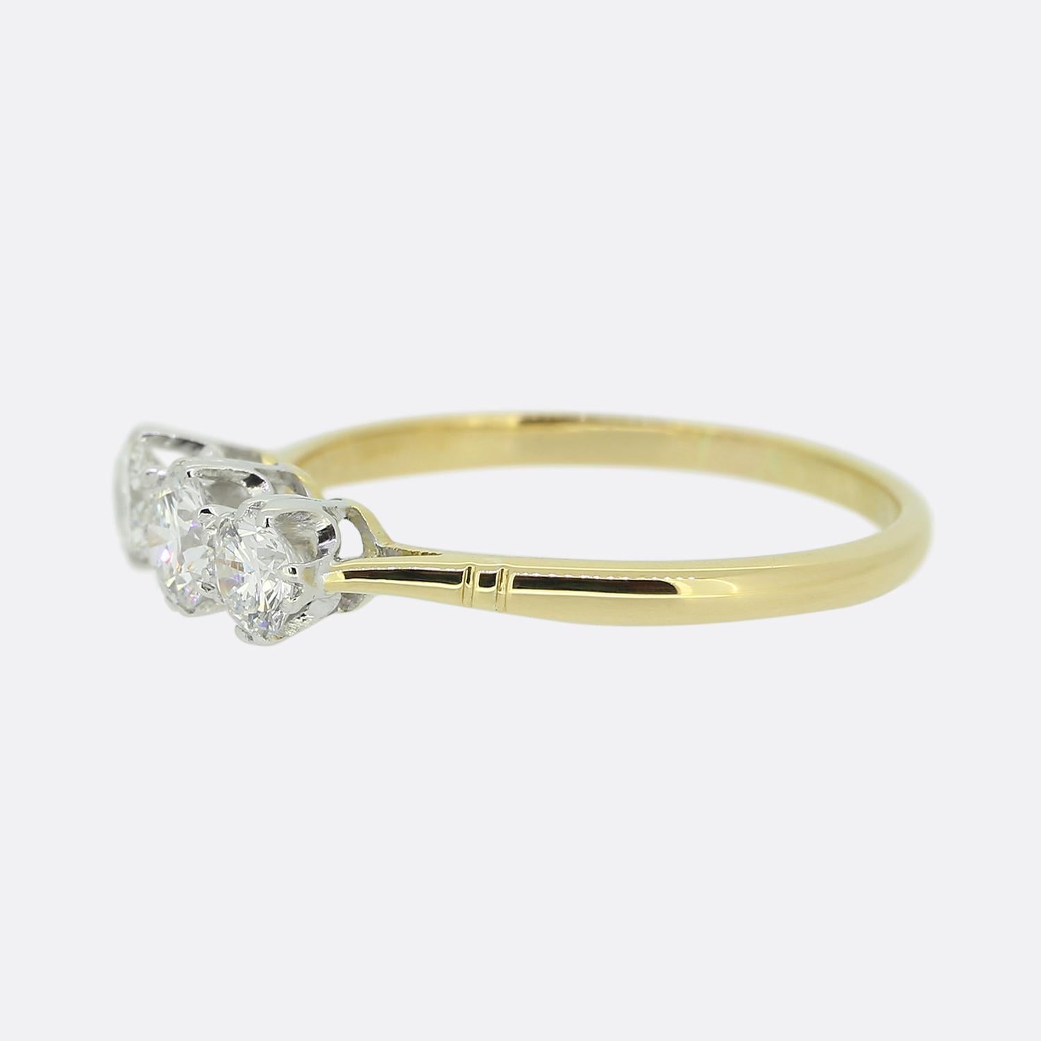Here we have a lovely, classically styled three-stone ring. A trio of well matched round brilliant cut diamonds have been individually claw set in white gold across the centre of the face in a single line formation atop a slim 18ct yellow gold band.