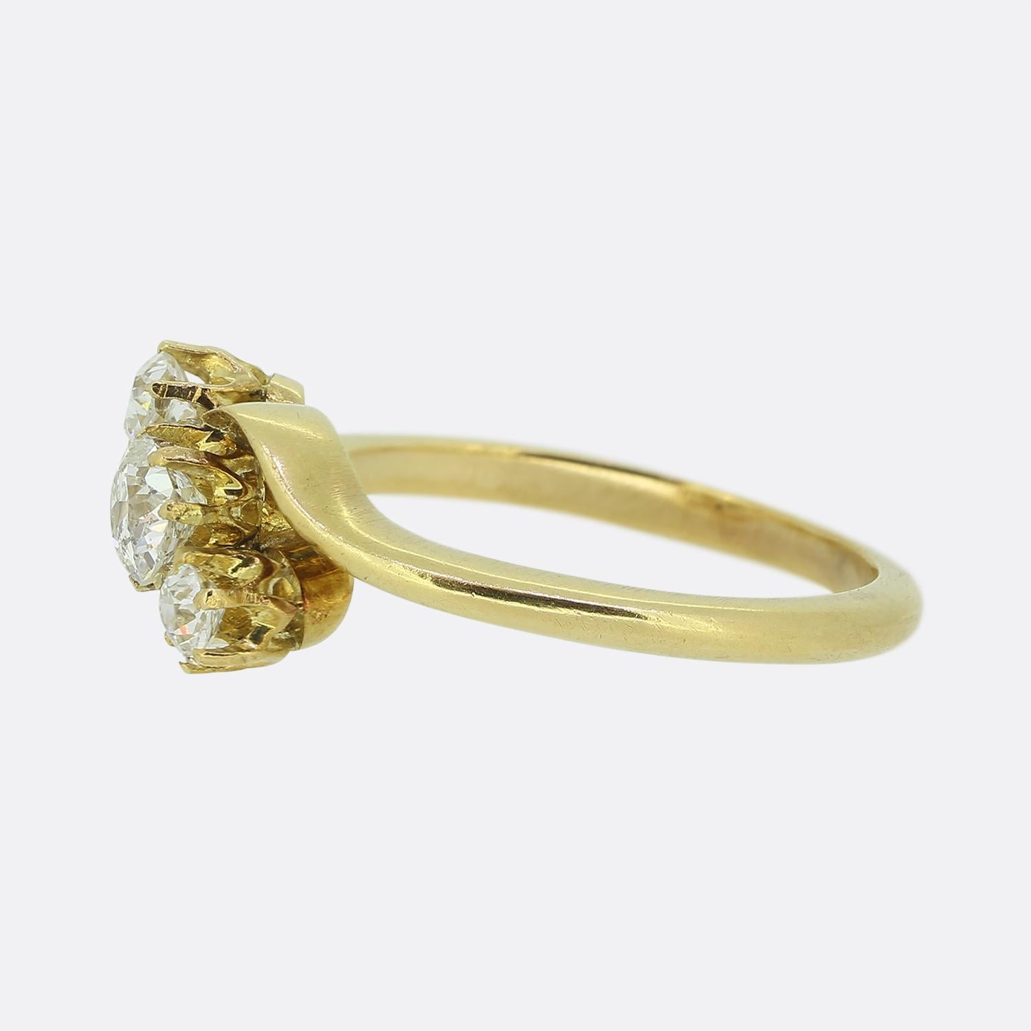 Here we have a vintage 18ct yellow gold three-stone diamond twist ring featuring three round faceted old cut diamonds. The central stone (0.30ct) is set in a eight pronged mount as are the two single round (each 0.11ct) diamonds on either