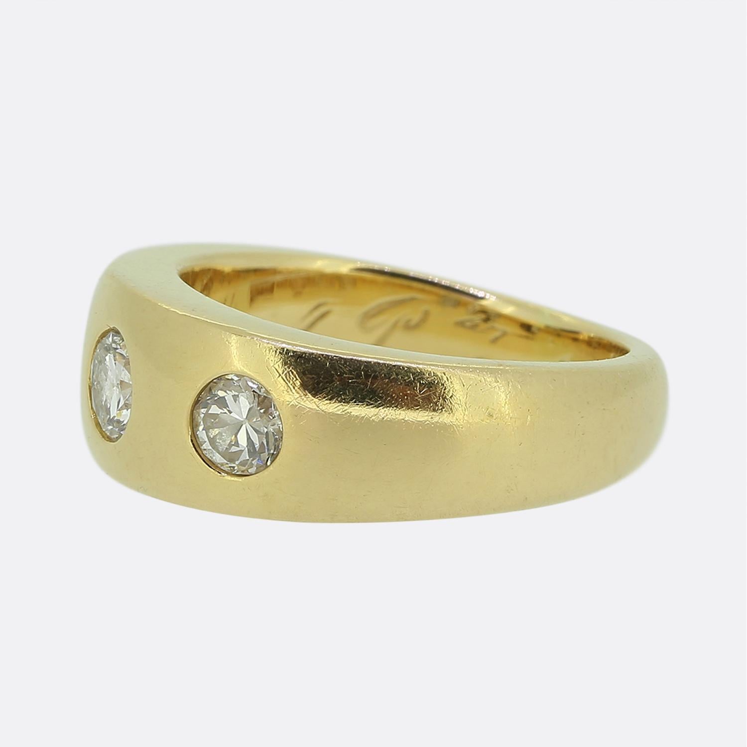 Here we have a classically styled three-stone diamond ring. This vintage piece features a trio of round faceted transitional-cut diamonds, each neatly bezel set within an unembellished 18ct yellow gold band. The diamonds are evenly spaced, creating