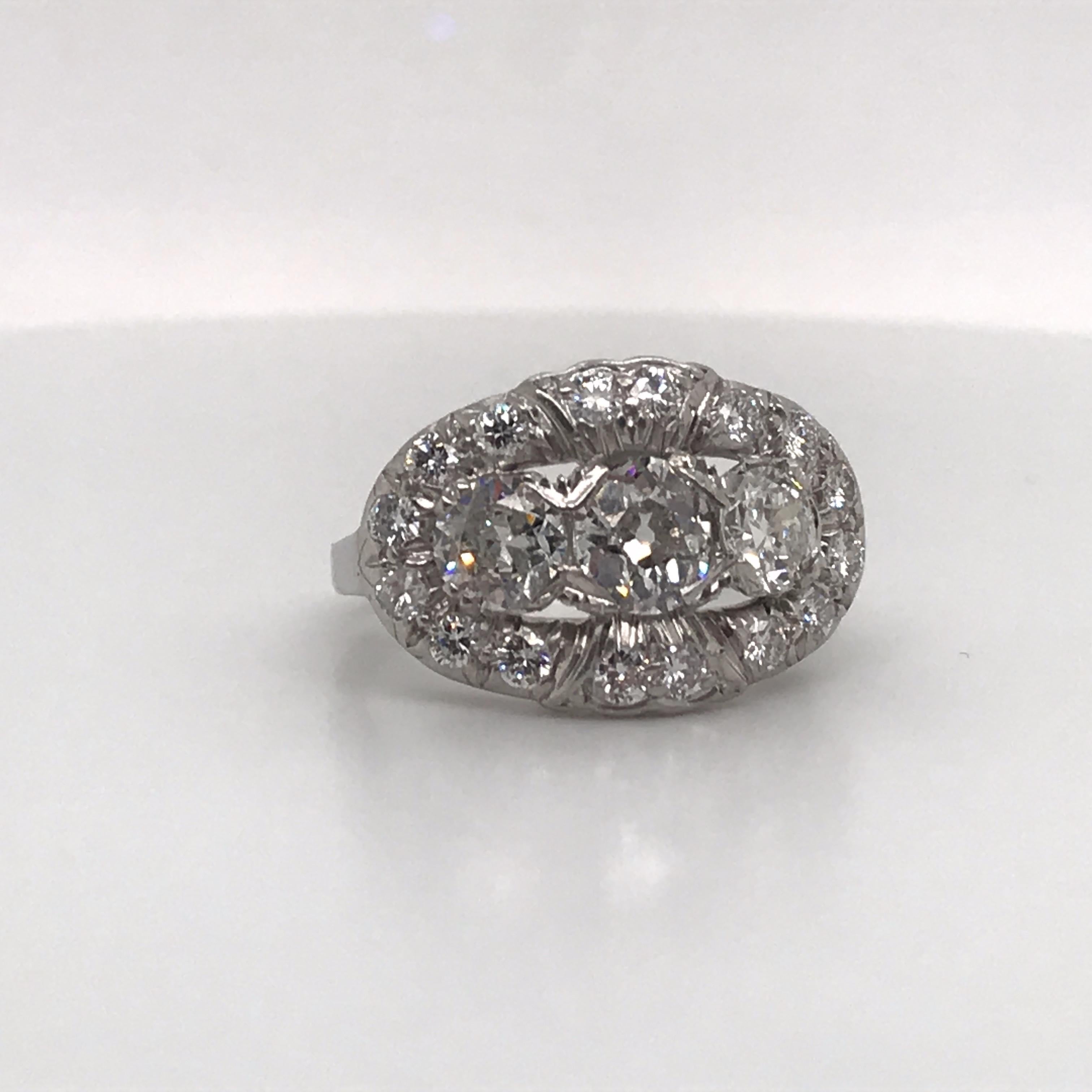 Vintage diamond ring featuring three diamonds flanked with smaller diamonds weighing approximately 2 carats, crafted in platinum.