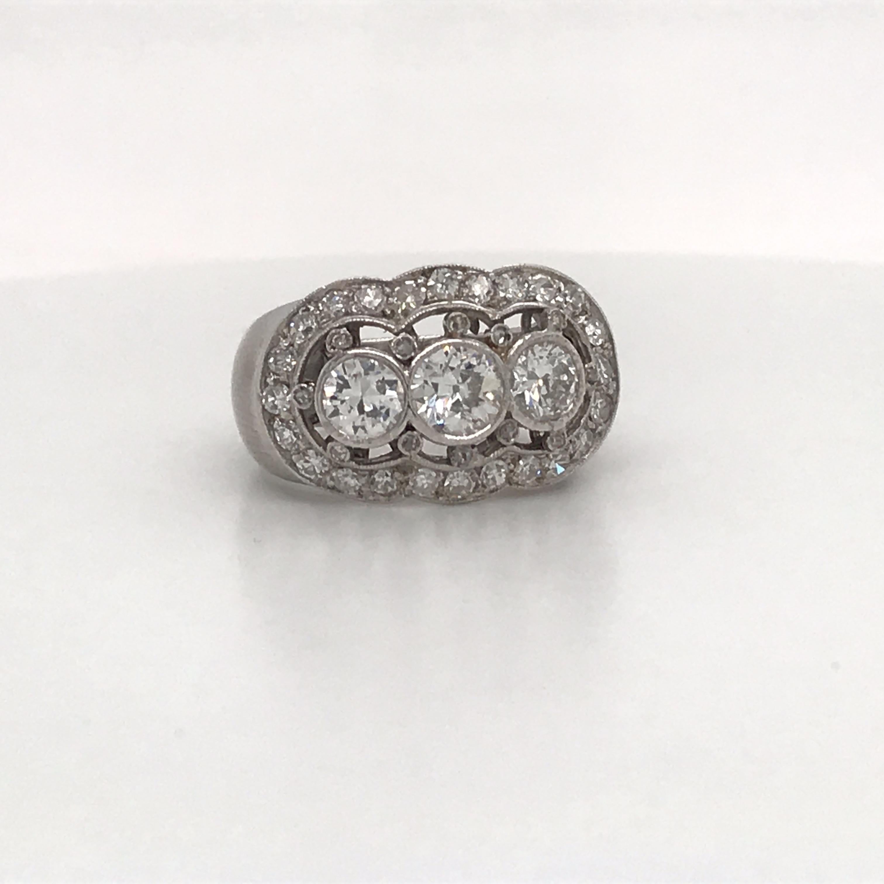 Vintage diamond ring featuring three diamonds flanked with smaller diamonds weighing approximately 2 carats, crafted in platinum. 