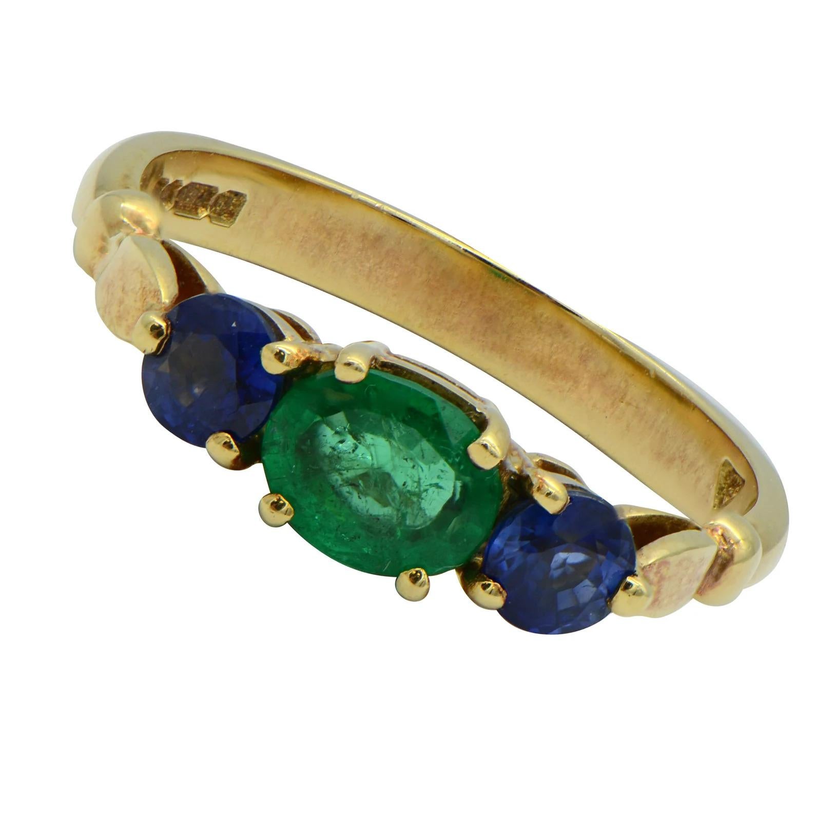 Vintage Three Stone Emerald and Sapphire Engagement Ring 18K Yellow Gold

This three stone ring is a truly splendid example of vintage jewelry. Featuring an elegant green emerald nestled between two round blue sapphires, this ring has a very unique