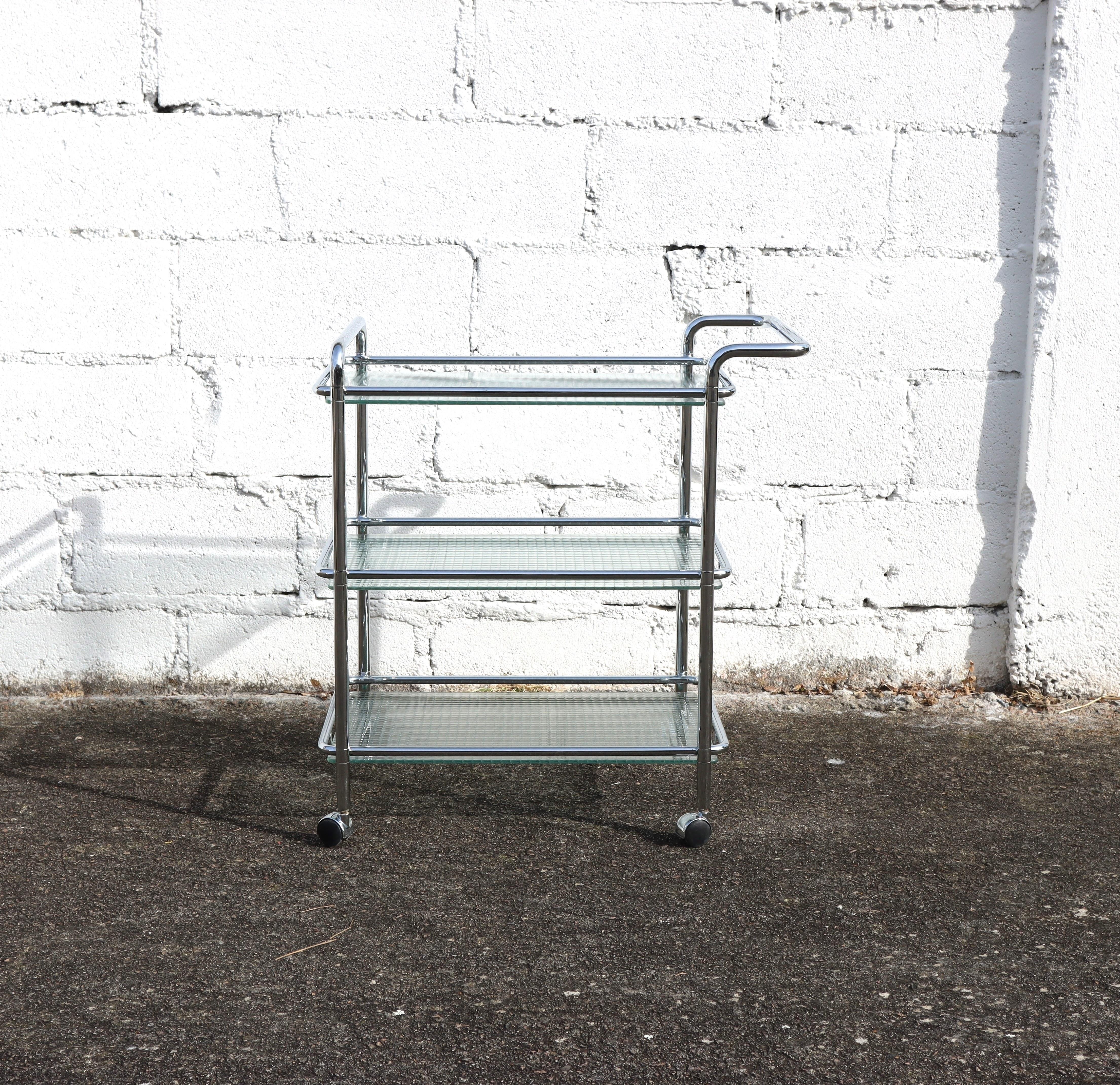 Vintage Postmodern three Tier Chrome Glass Serving Trolley from from the End of the 80s

Heavy Wire Glass Panels in a Space Age Style Chrome tubular Frame.
Functional and versatile - ideal Serving Trolley for your Living Area or Patio.
wonderful