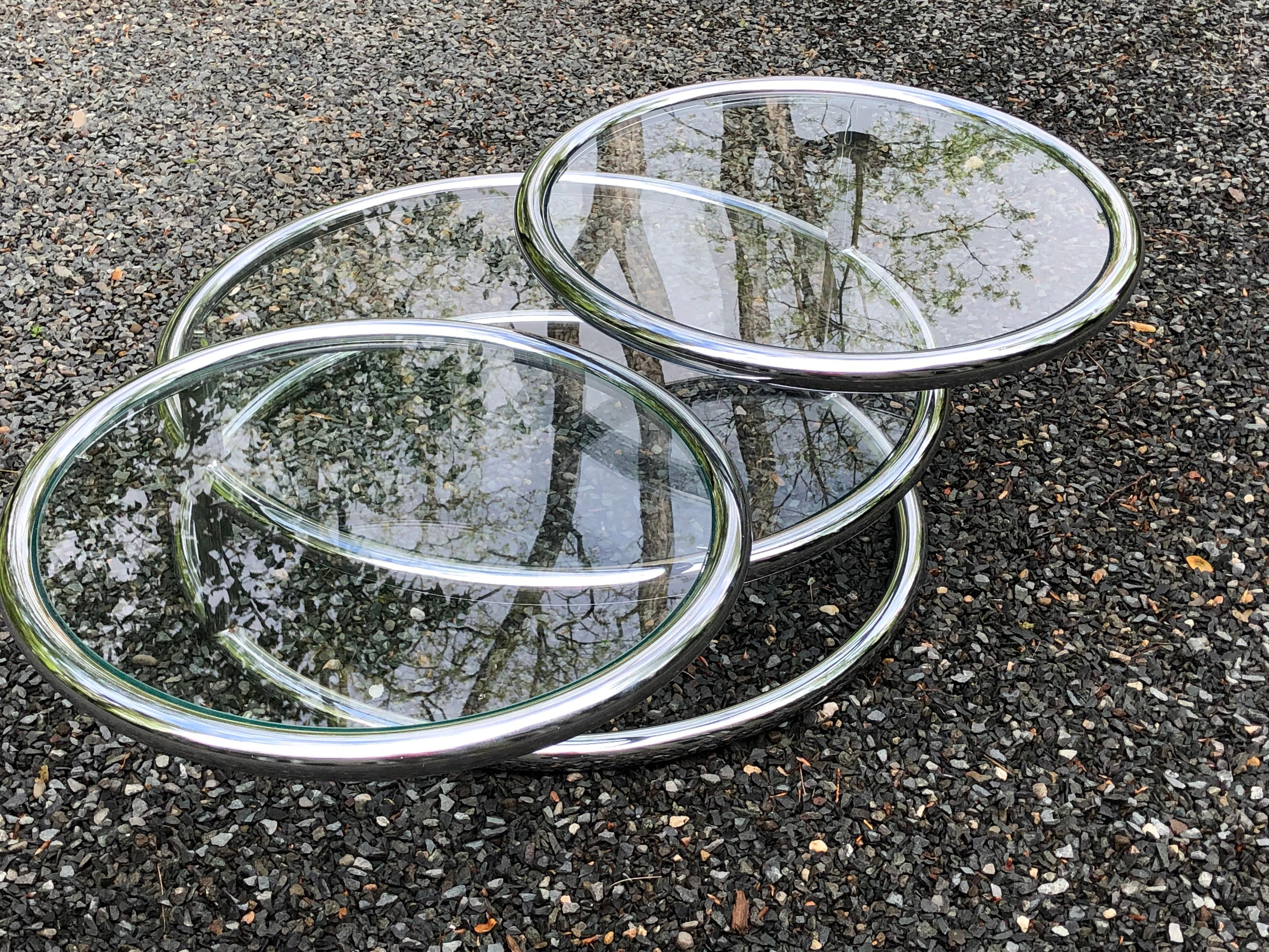 Superbly designed articulating 3 tier coffee table having tubular chrome and glass tabletops. The two smaller tiers swivel seamlessly 360 degrees.