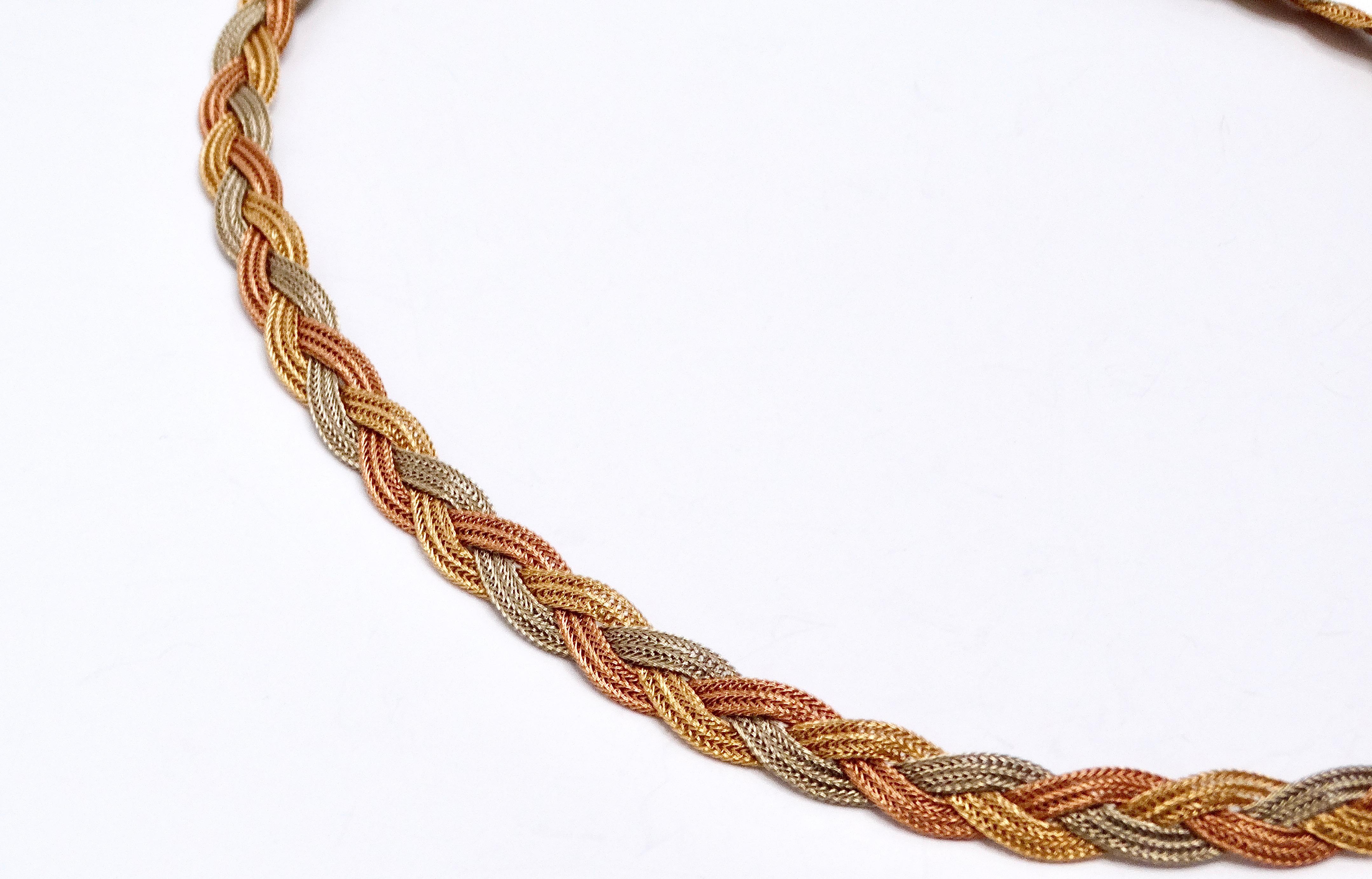 The Vintage Three-Tone 14k Gold Braided Necklace is an exquisite piece of jewelry that showcases the artistry and elegance of vintage craftsmanship. Made from 14k gold, this necklace features an intricate braided design that combines yellow, white,
