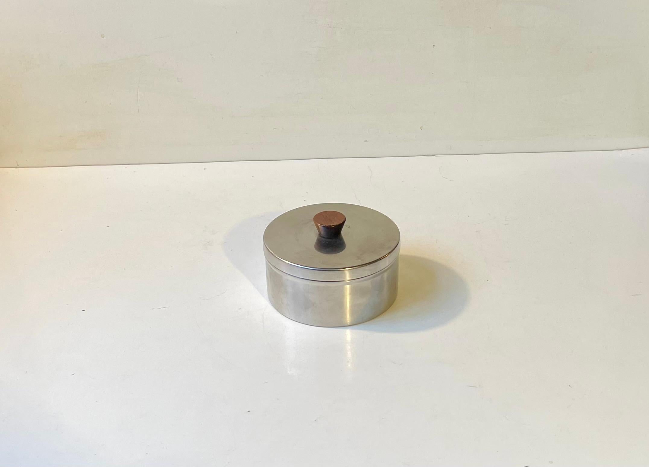 Un superbe pot ou bibelot composé d'acier inoxydable brossé et d'un bouton pratique en teck. Le couvercle est bien ajusté et ne laisse pas passer l'air. Parfait pour conserver du thé délicat, du tabac ou du caviar.
Ce design est attribué au célèbre